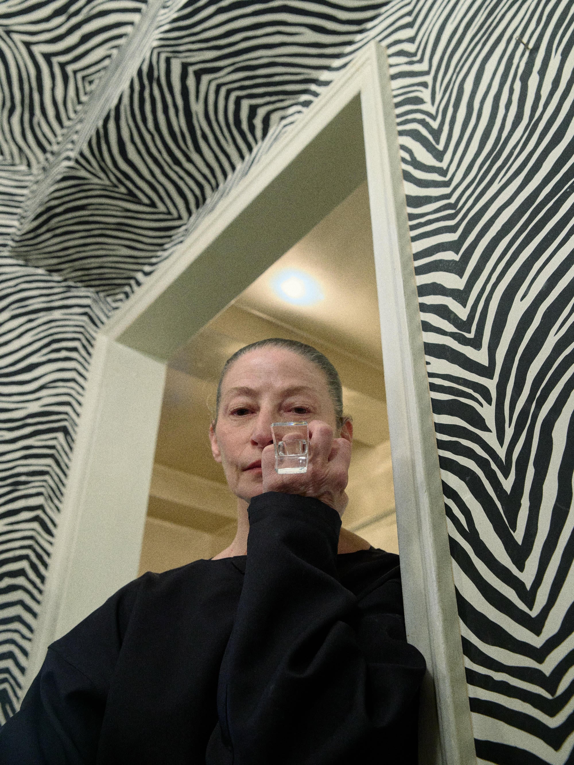 Person holding a transparent ring in front of a zebra-striped wall