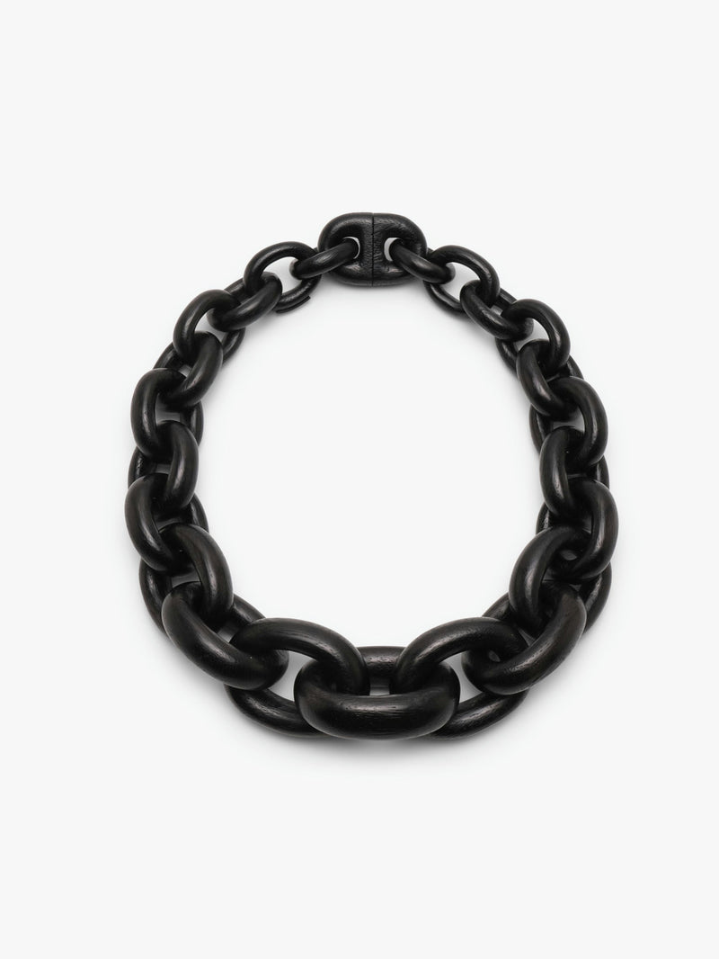 A black acacia wood necklace with a magnetic lock, displayed on a plain background.