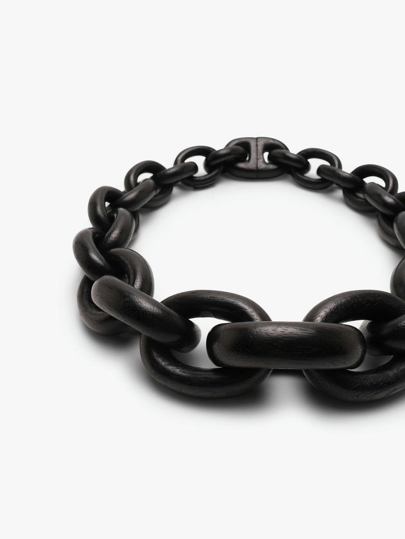 A black acacia wood necklace with a magnetic lock, displayed on a plain background.