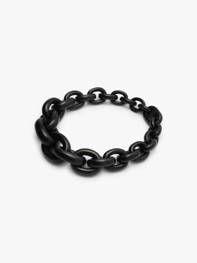 A black acacia wood necklace with a magnetic lock, displayed on a plain background.