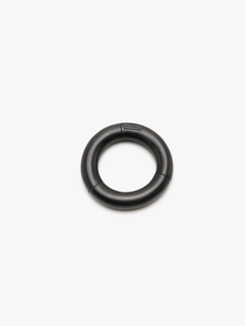 A black slip-on bracelet made of acacia, displayed on a white background.