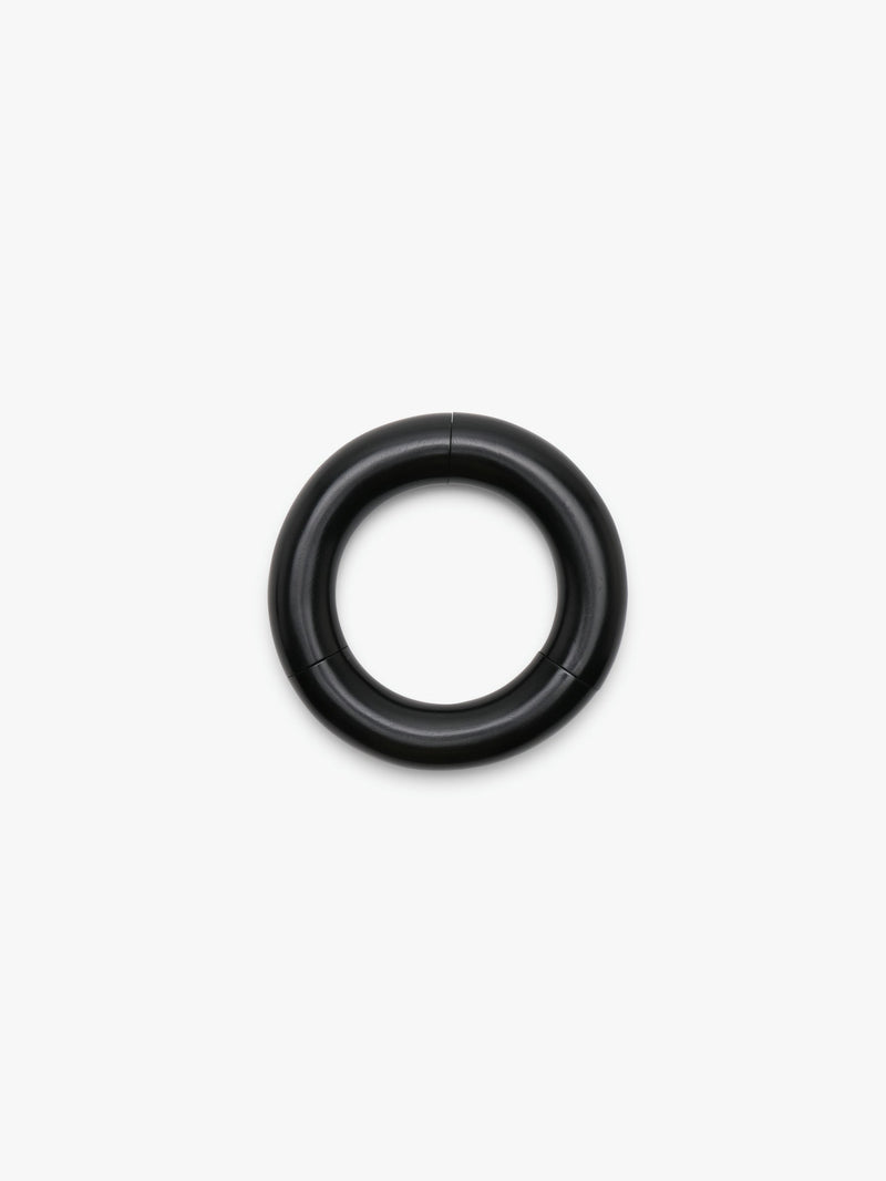 A black slip-on bracelet made of acacia, displayed on a white background.