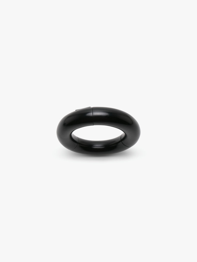 A black slip-on bracelet made of acacia, displayed on a white background.