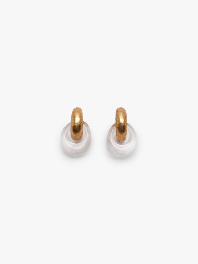 Pair of gold and white hoop earrings on a light beige background