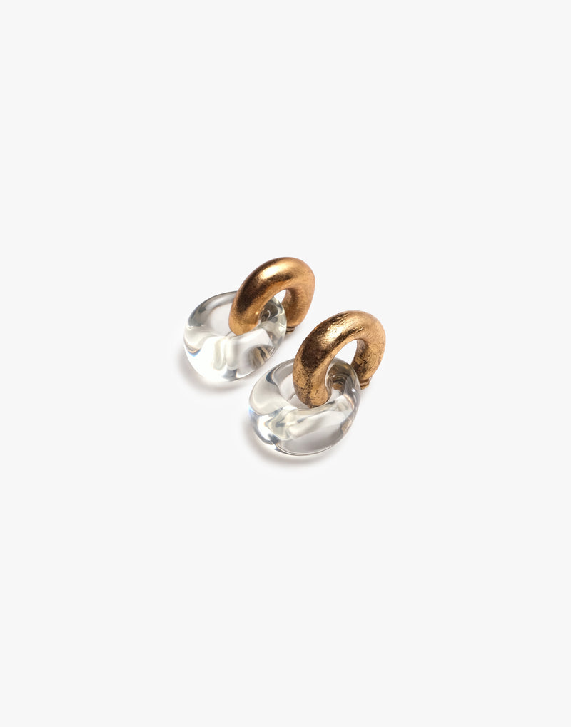 Pair of gold and white hoop earrings on a light beige background