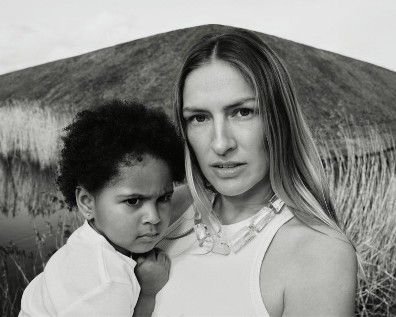 Image of a woman holding a child wearing a mountain crystal necklace