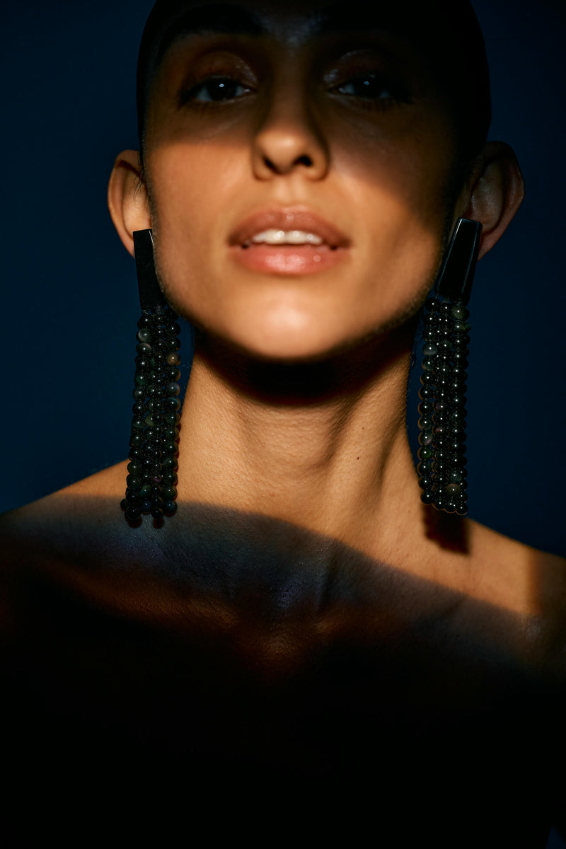 A pair of long black earrings with obsidian stone and acrylic tassels