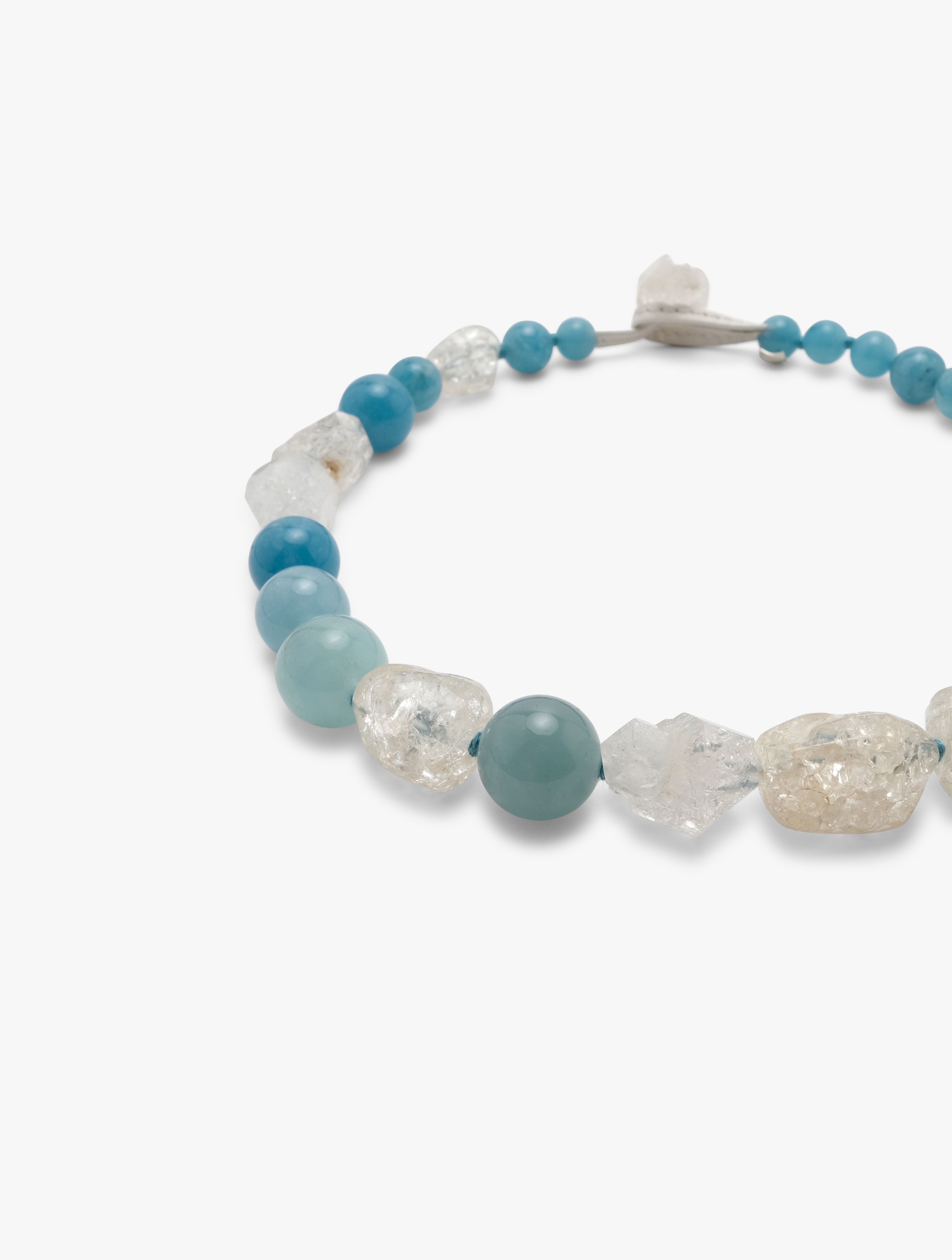 necklace made of blue and clear crystal beads displayed on a hite background