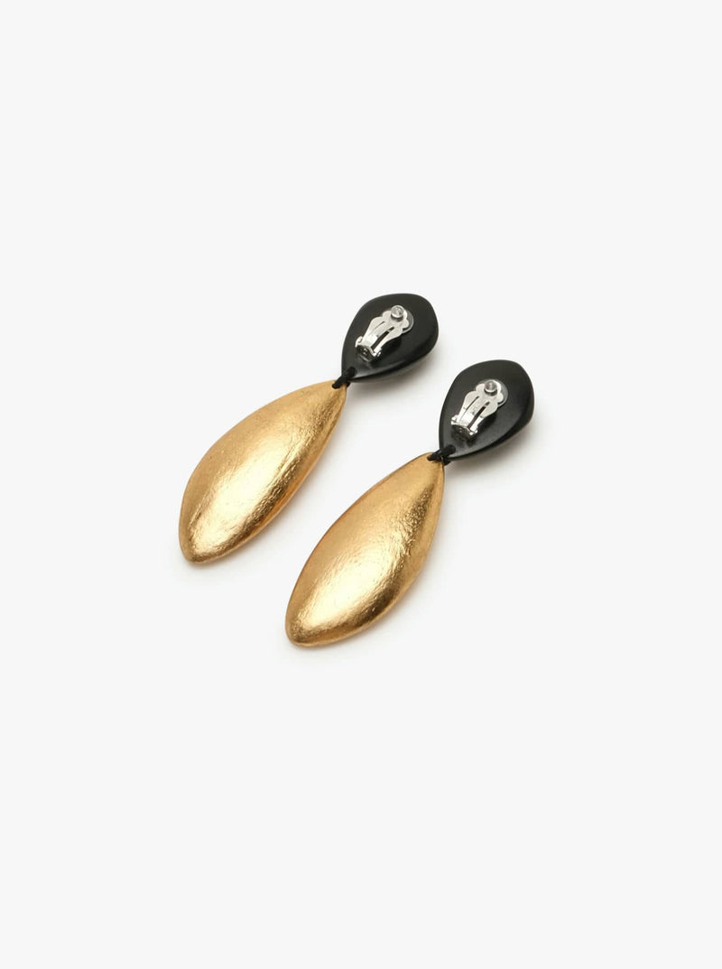 A pair of earclips with the upper part in black and lower part in gold tone against a white background.

