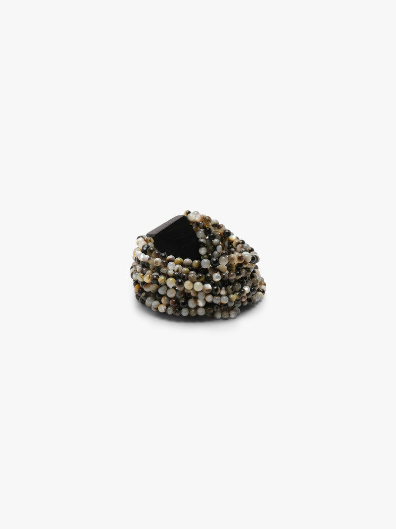 A wide pearl beaded wrap bracelet with a faceted black acacia  lock, displayed on a clean white background.