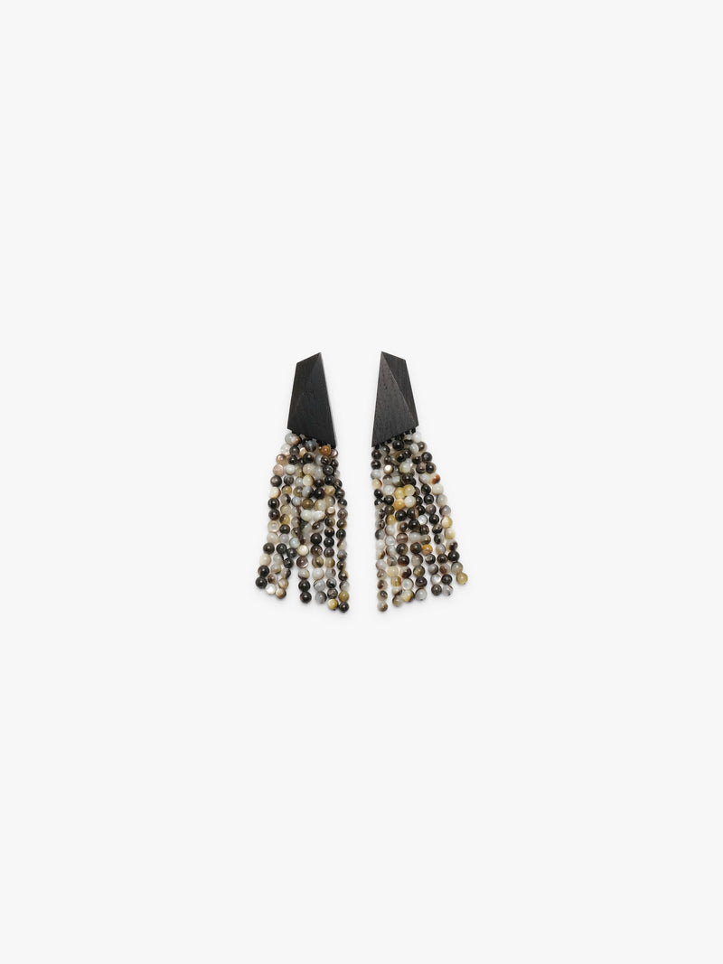 A pair of statement dangle earrings with matte black triangular tops and cascading fringe made of pearl beads, shown on a plain light gray background.