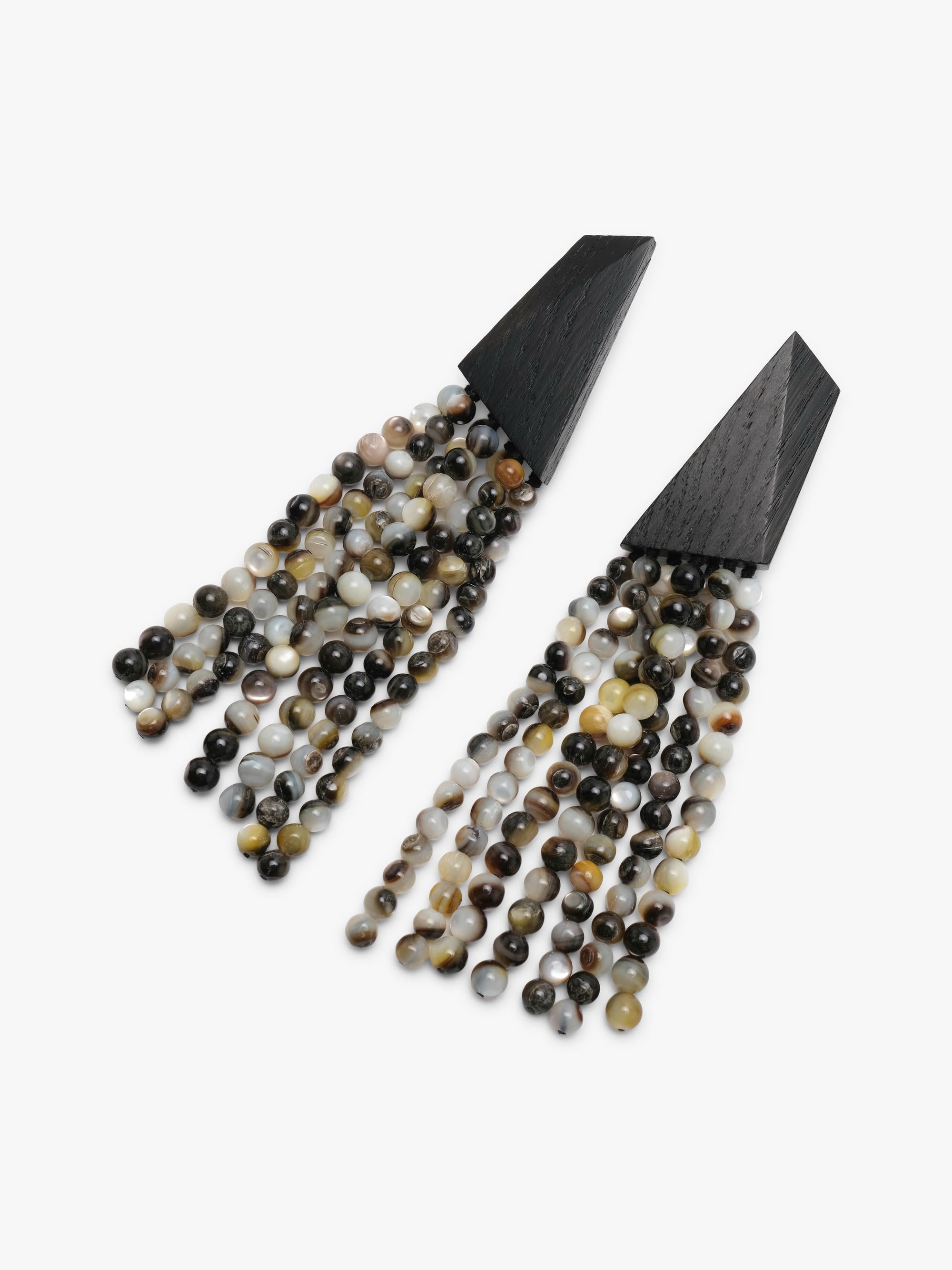A pair of statement dangle earrings with matte black triangular tops and cascading fringe made of pearl beads, shown on a plain light gray background.