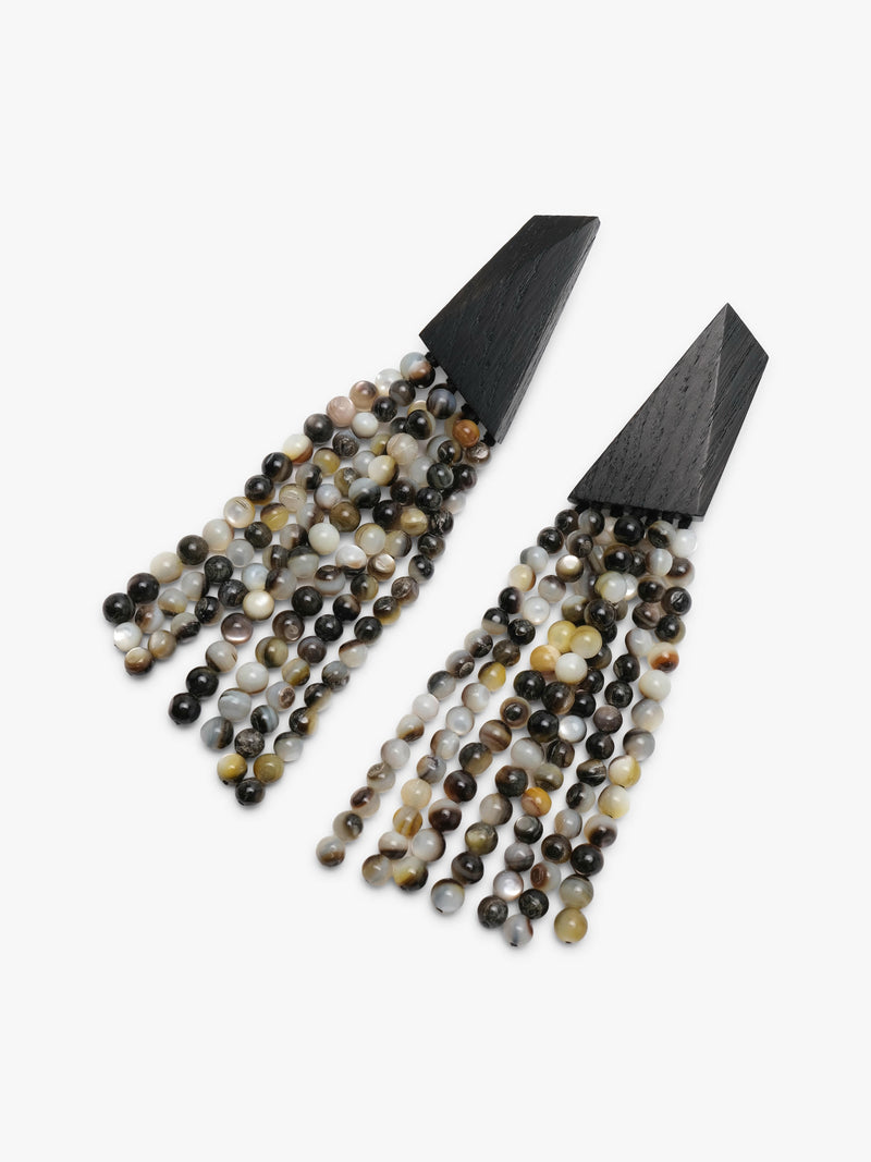 A pair of statement dangle earrings with matte black triangular tops and cascading fringe made of pearl beads, shown on a plain light gray background.