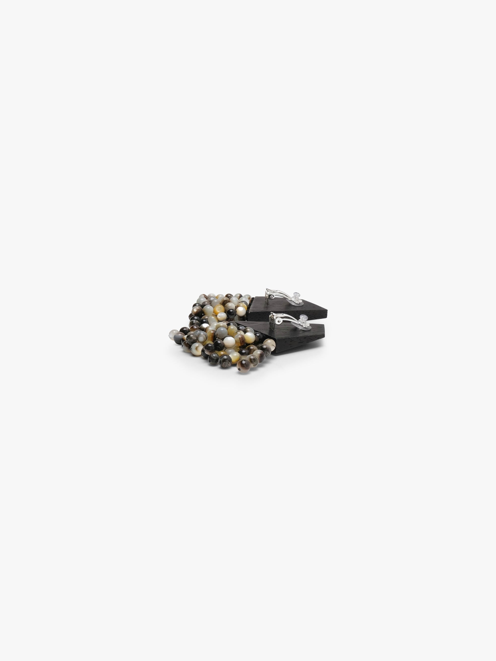 A pair of statement earrings featuring dark wood tops and cascading clusters of polished pearl beads in black, gray, white, and brown, set against a plain white background.