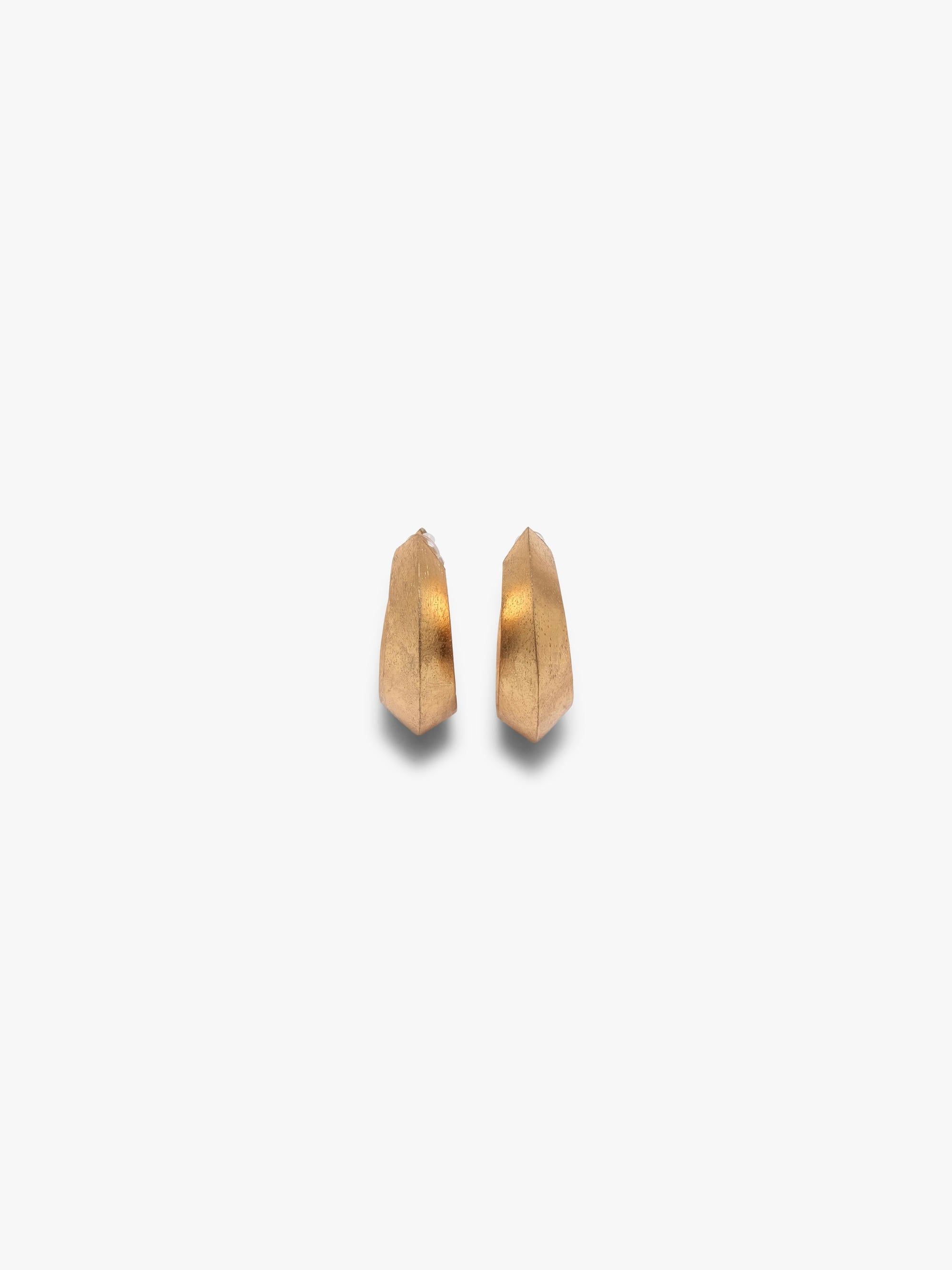 A pair of gold crescent-shaped hoop earrings with a textured finish, displayed on a clean, light off-white background.