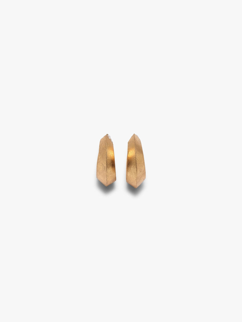 A pair of gold crescent-shaped hoop earrings with a textured finish, displayed on a clean, light off-white background.