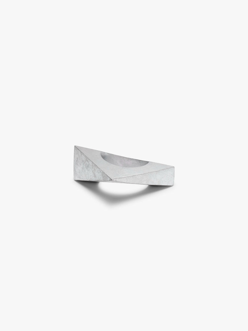 A silver geometric bracelet with a faceted, diamond-like shape and a circular center hole, shown on a plain light gray background.