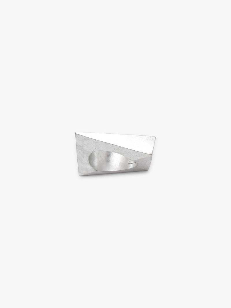 A silver geometric bracelet with a faceted, diamond-like shape and a circular center hole, shown on a plain light gray background.