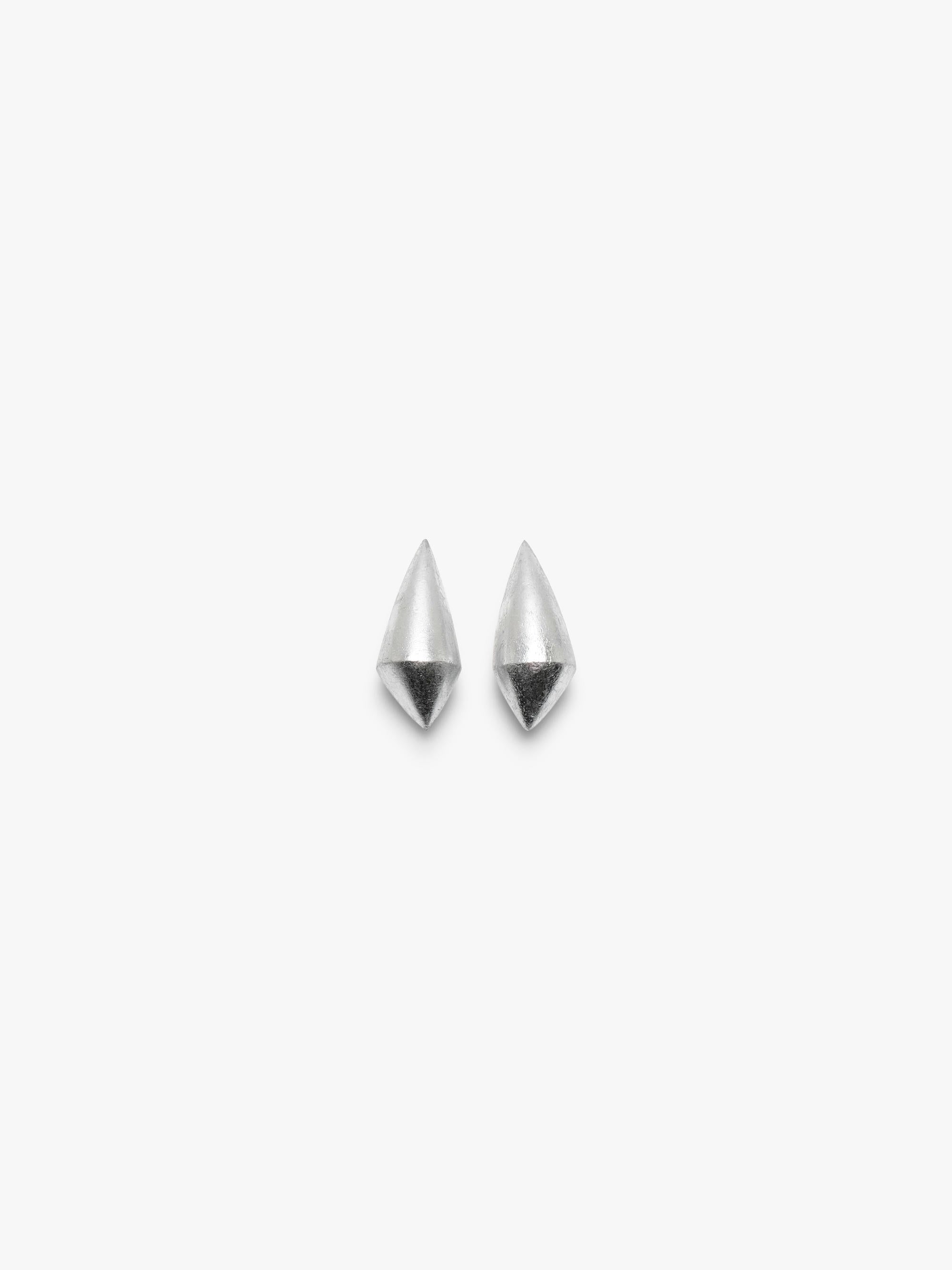 A pair of elongated earrings covered in silverfoil, displayed on a white background