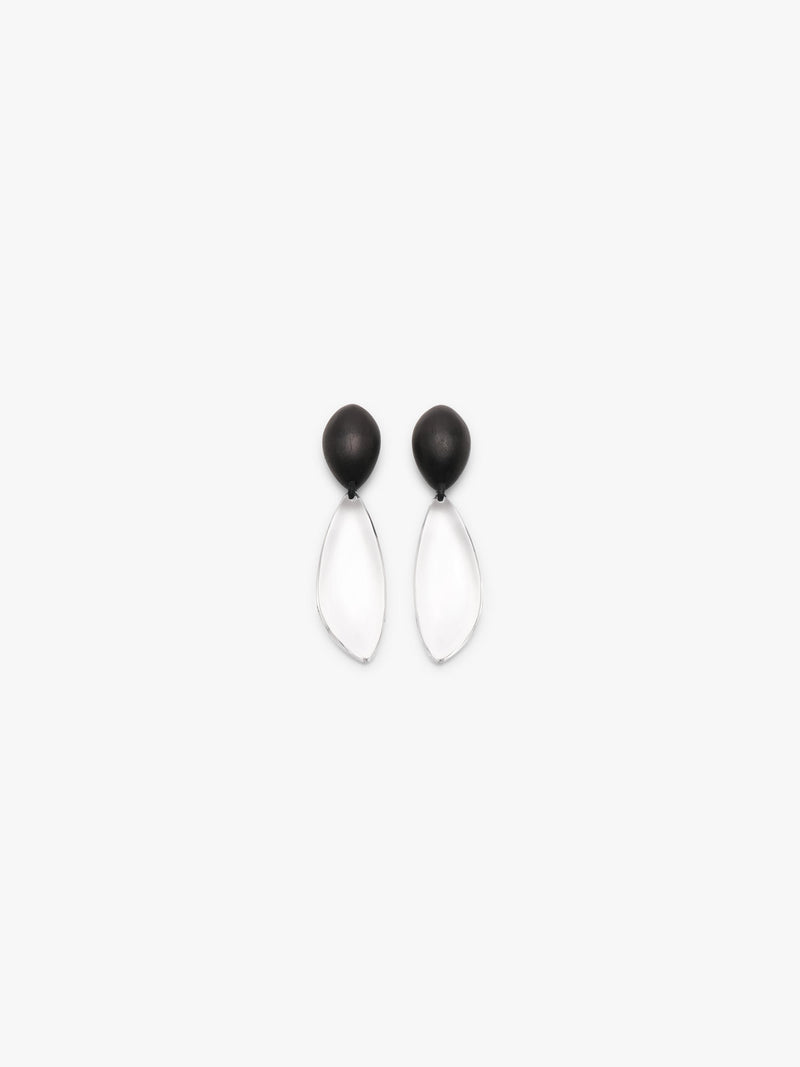 A pair of minimalist dangle earrings with matte black oval studs and clear teardrop-shaped drop pendants, shown against a solid white background.