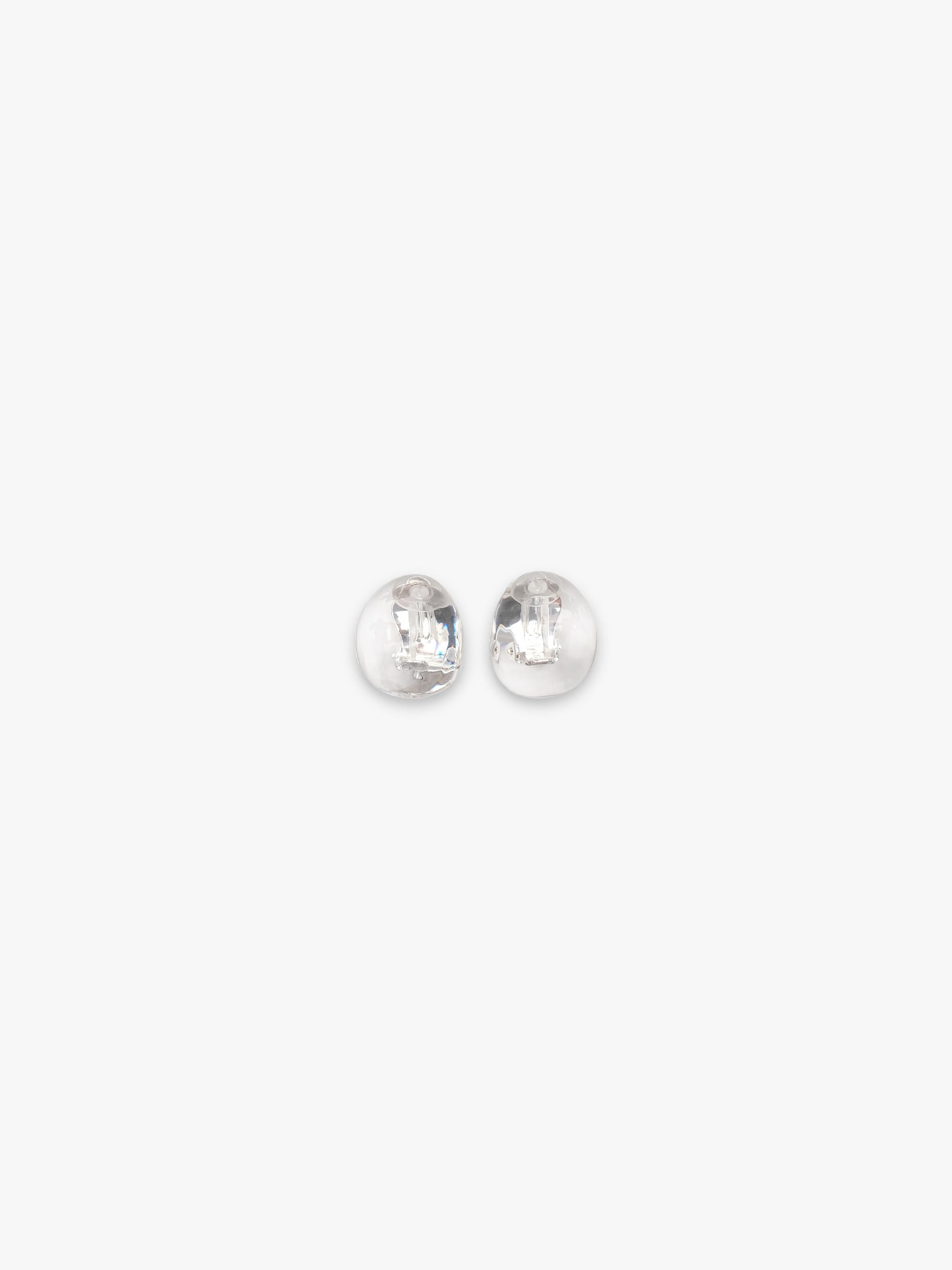 A pair of rounded transparent earrings, displayed on a white background