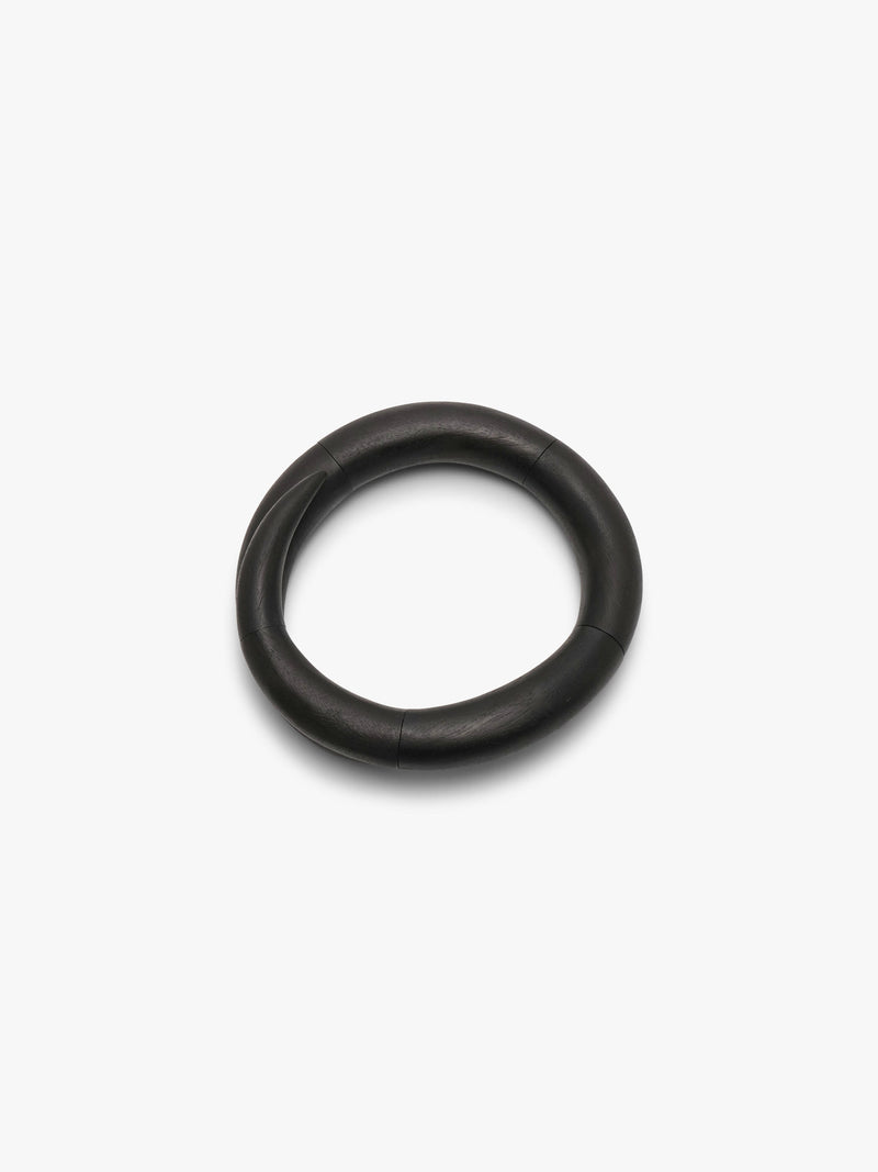 A spiraling black necklace with a thick, rounded profile, photographed on a clean white background.