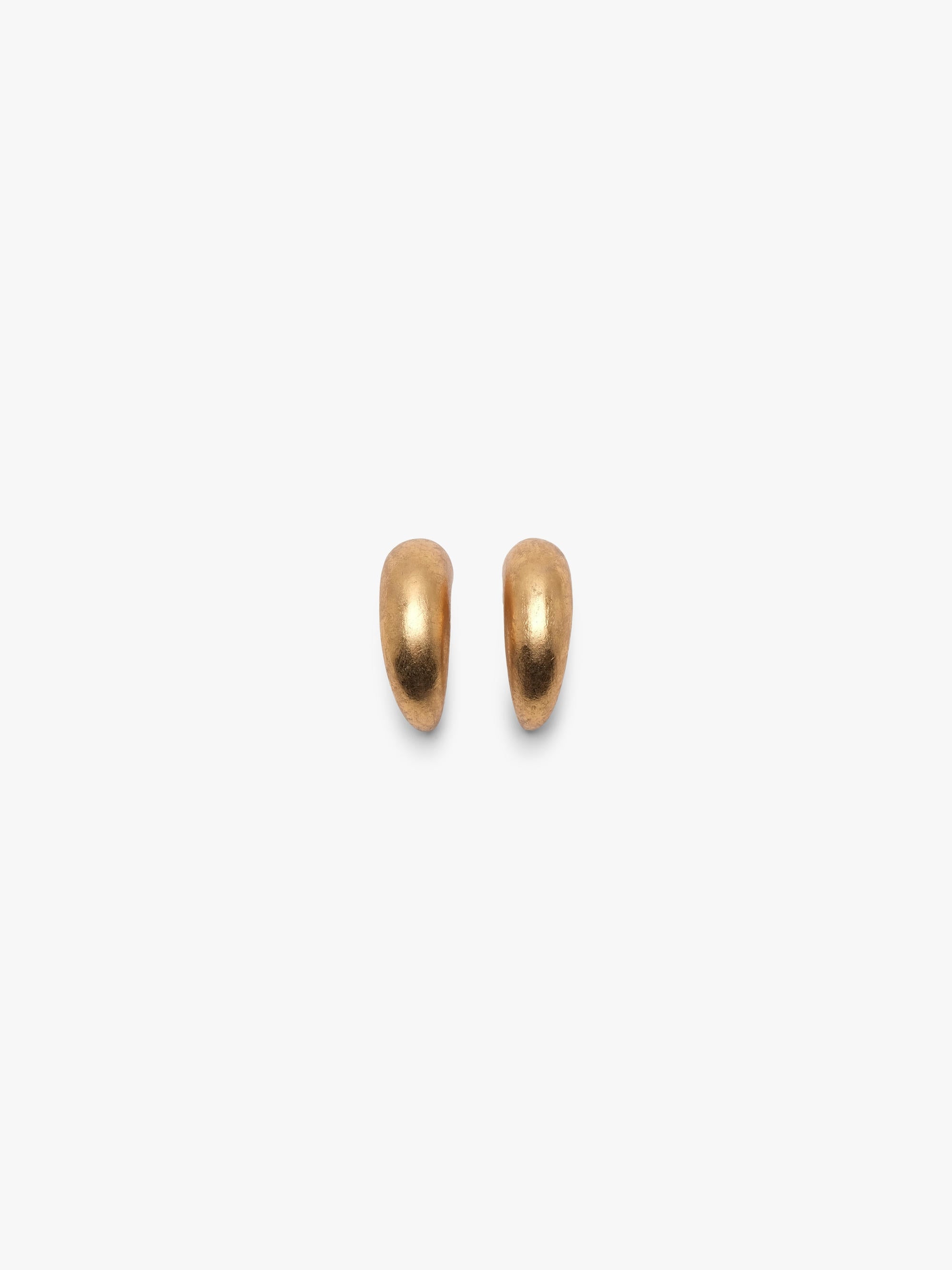 A pair of gold crescent-shaped hoop earrings with a small silver clip on feature, shown on a plain light gray background.