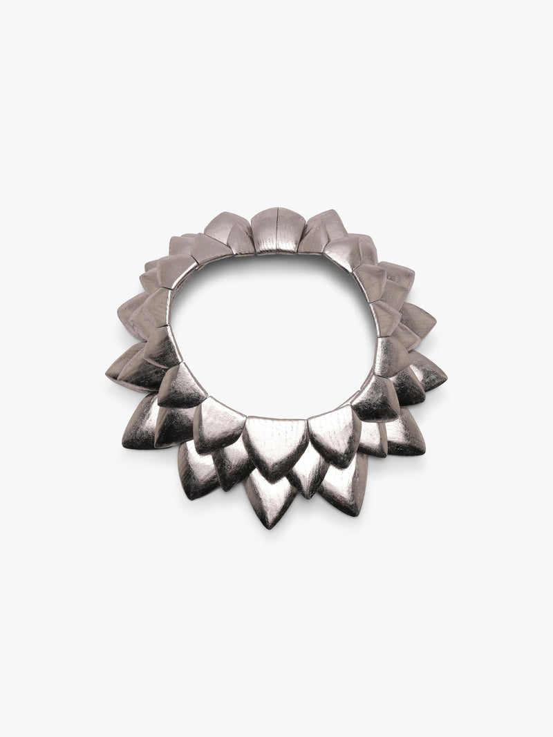 Silver necklace with many triangular shapes form into a circle, displayed on a white background