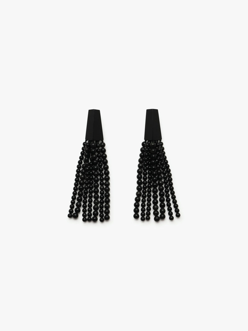A pair of long black earrings with obsidian stone and acrylic tassels, on a white background.