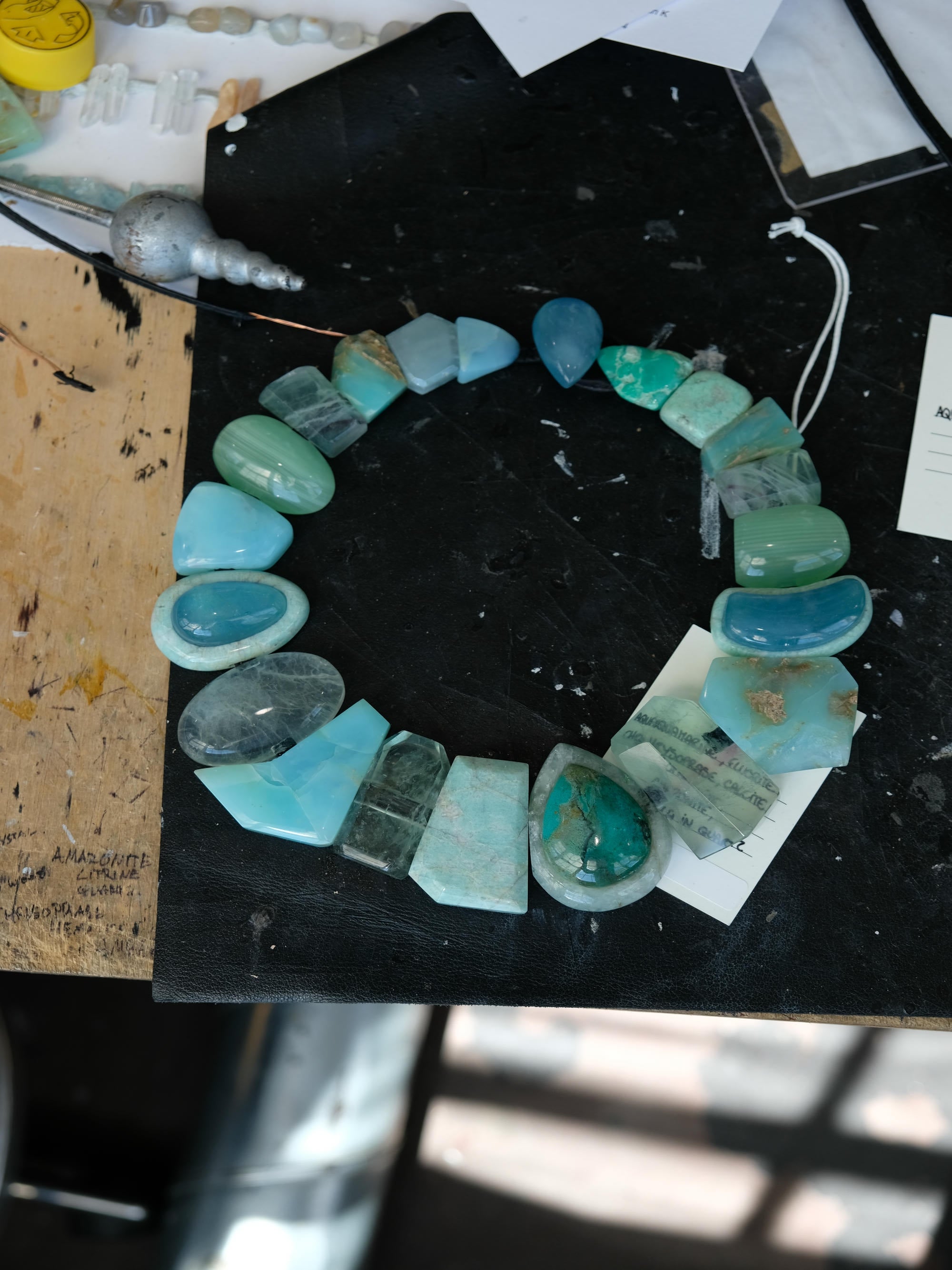 Turquoise stone necklace on a black surface with a blurred background