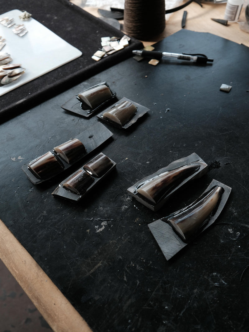 Horn pieces laying on a black surface in a workshop