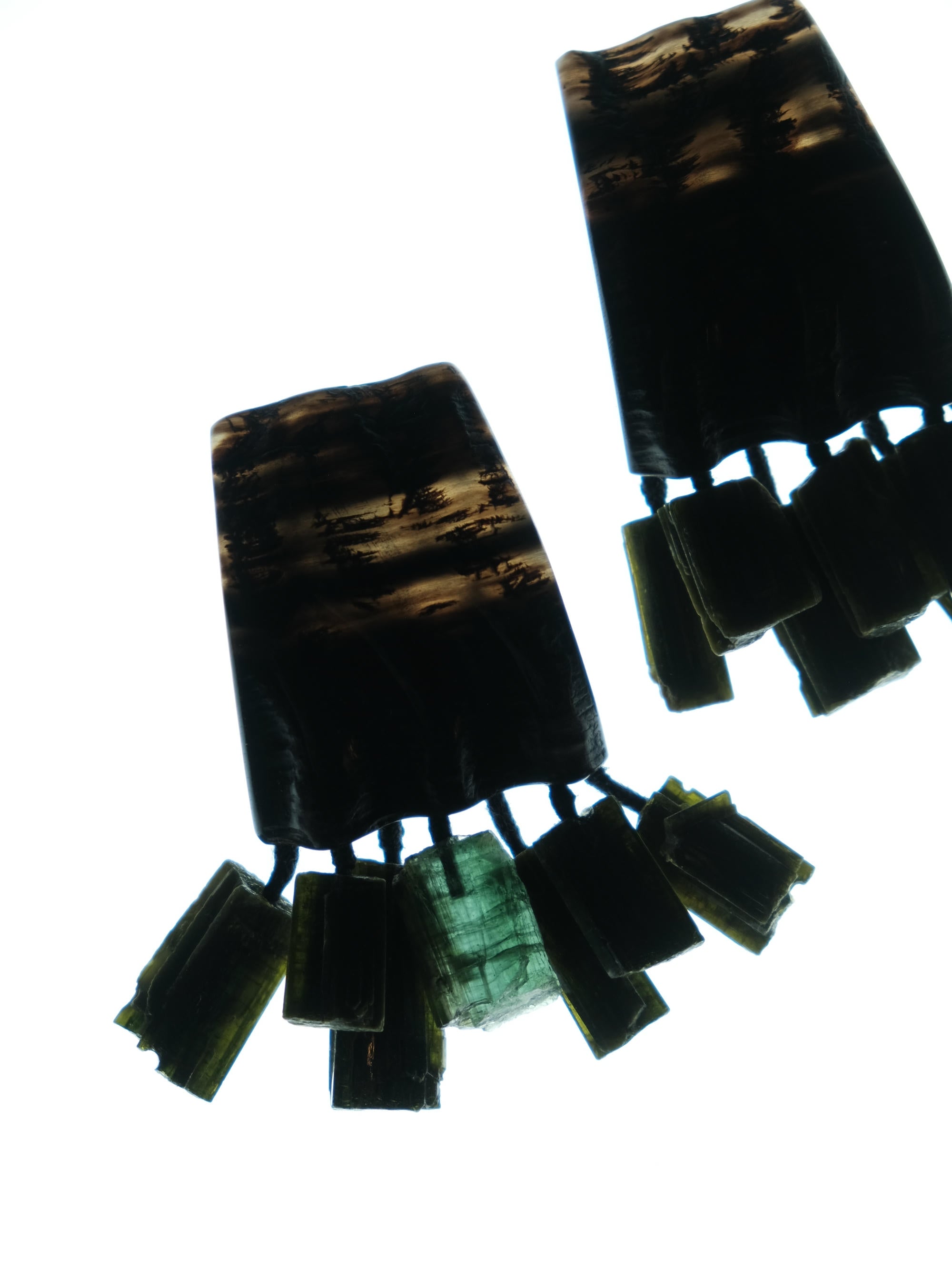 A pair of dark, textured rectangular earrings with multiple small hanging rectangular charms, shown against a solid white background.