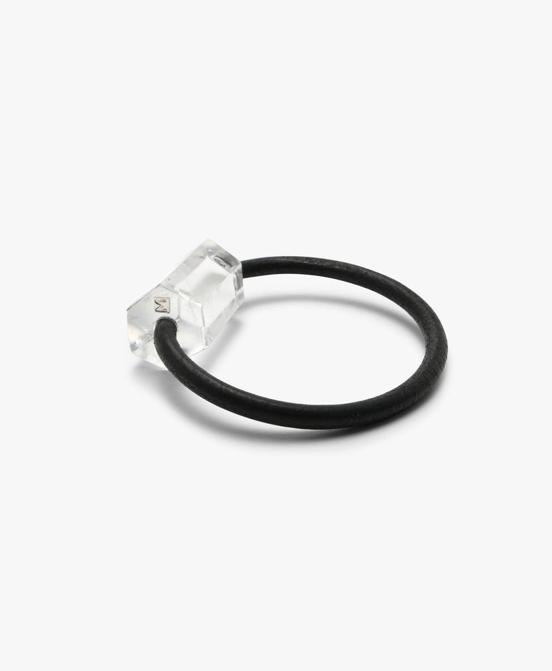 Black leather bracelet with a mountain crystal on a white background.