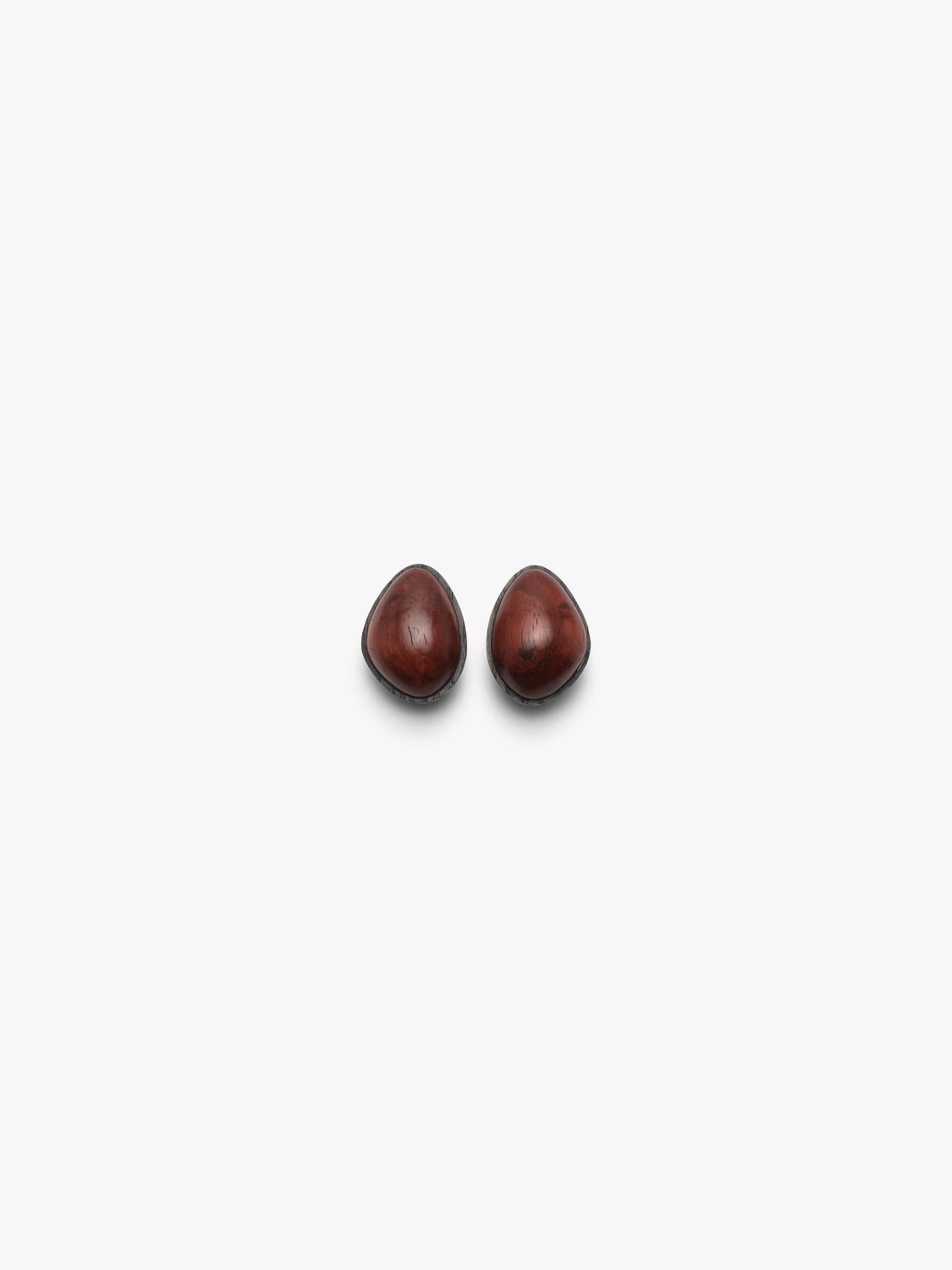 two small stud earrings ina  warm redtoned wood, displayed on a white background
