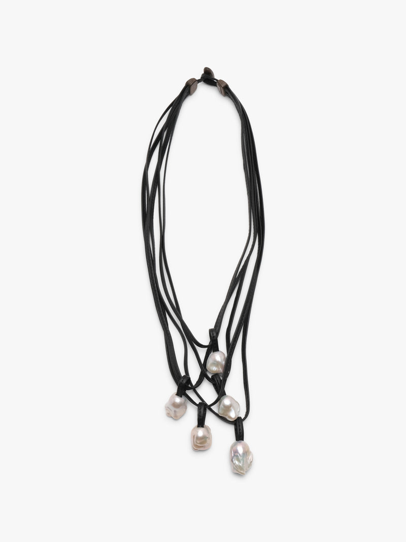 A necklace with white baroque pearls and leather straps, featuring a toggle clasp lock.