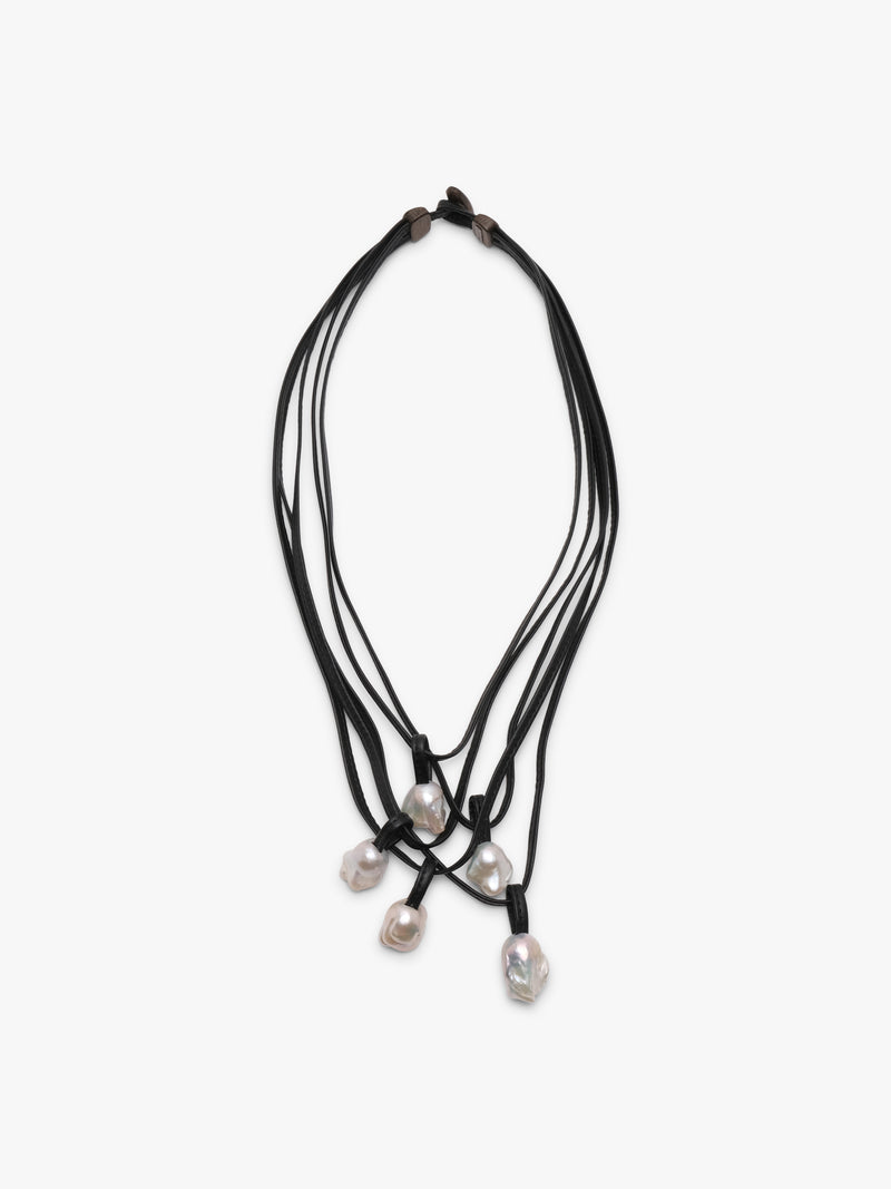 A necklace with white baroque pearls and leather straps, featuring a toggle clasp lock.