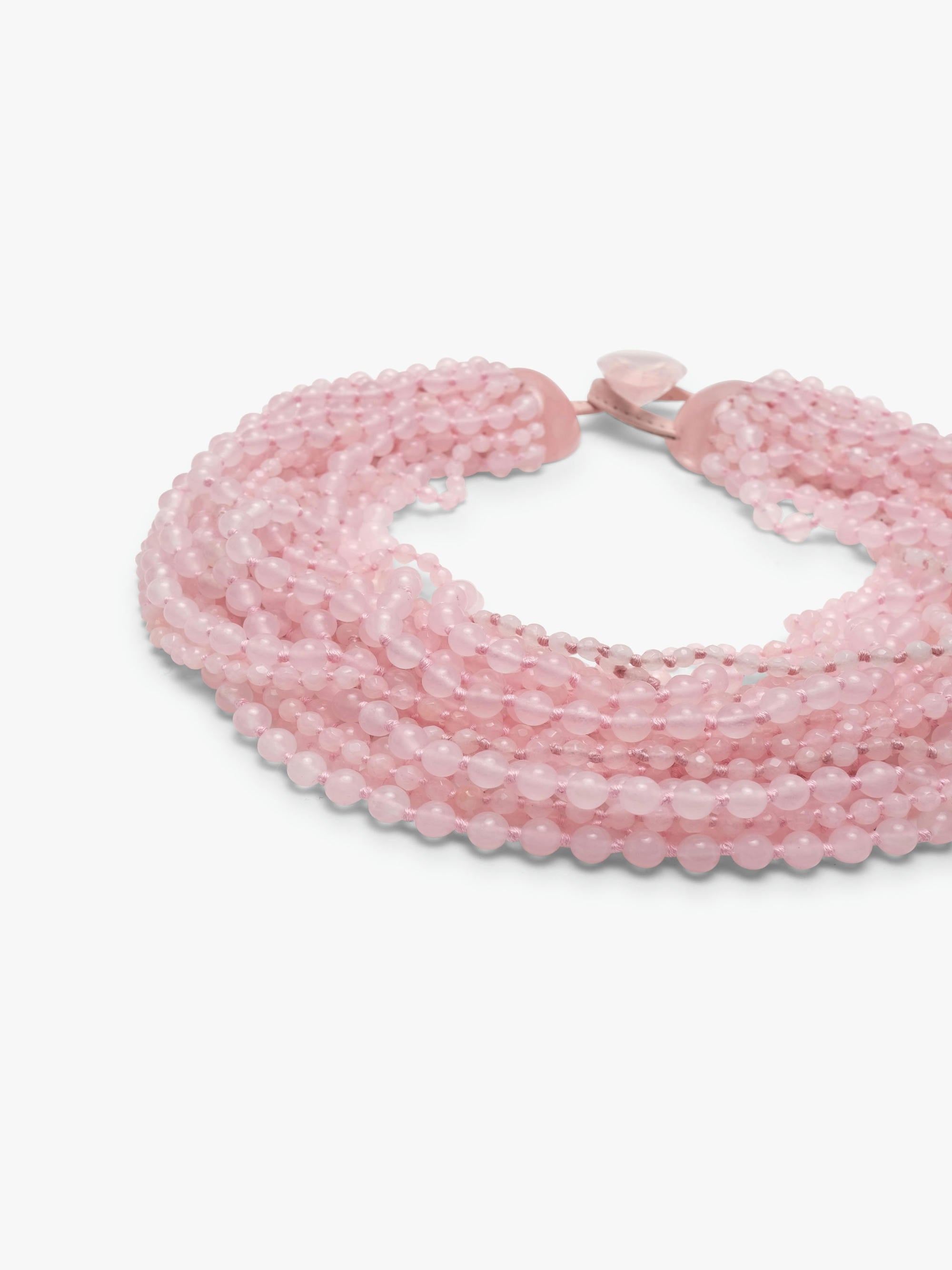A multi-strand pink beaded wrap necklace with a small pink heart charm, displayed on a clean white background.