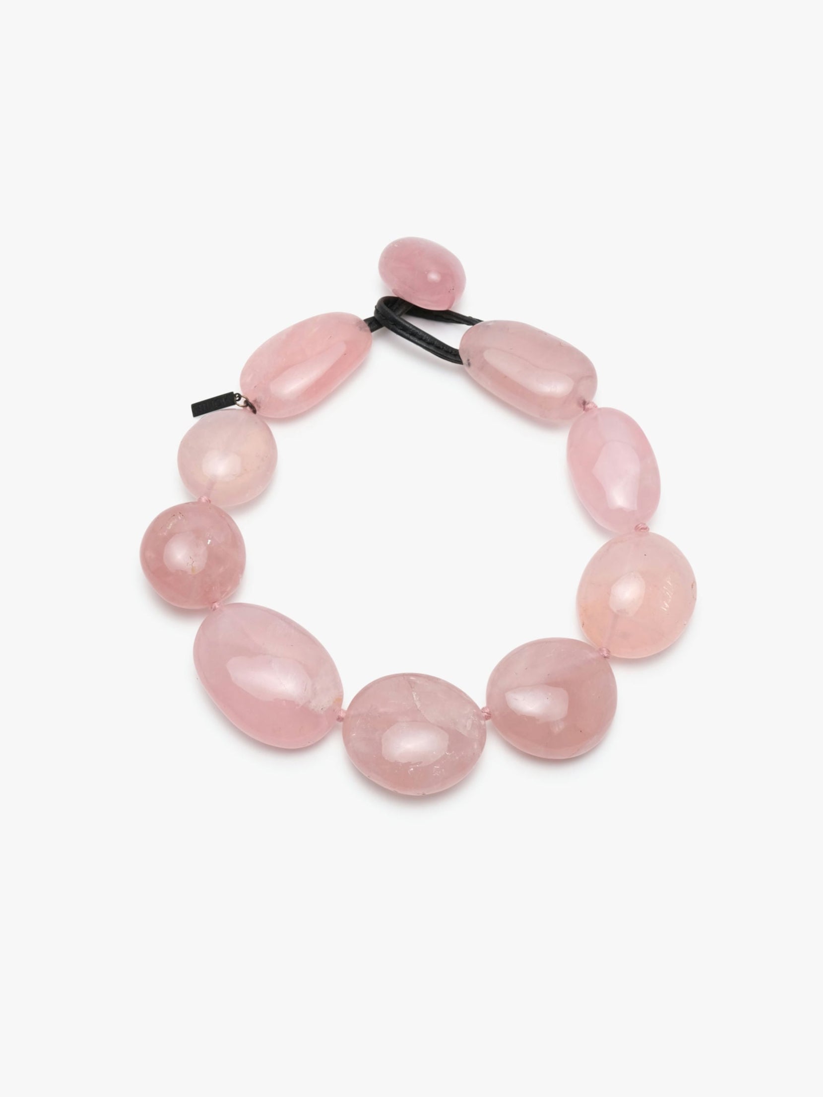 A necklace made of rose quartz with a leather clasp.