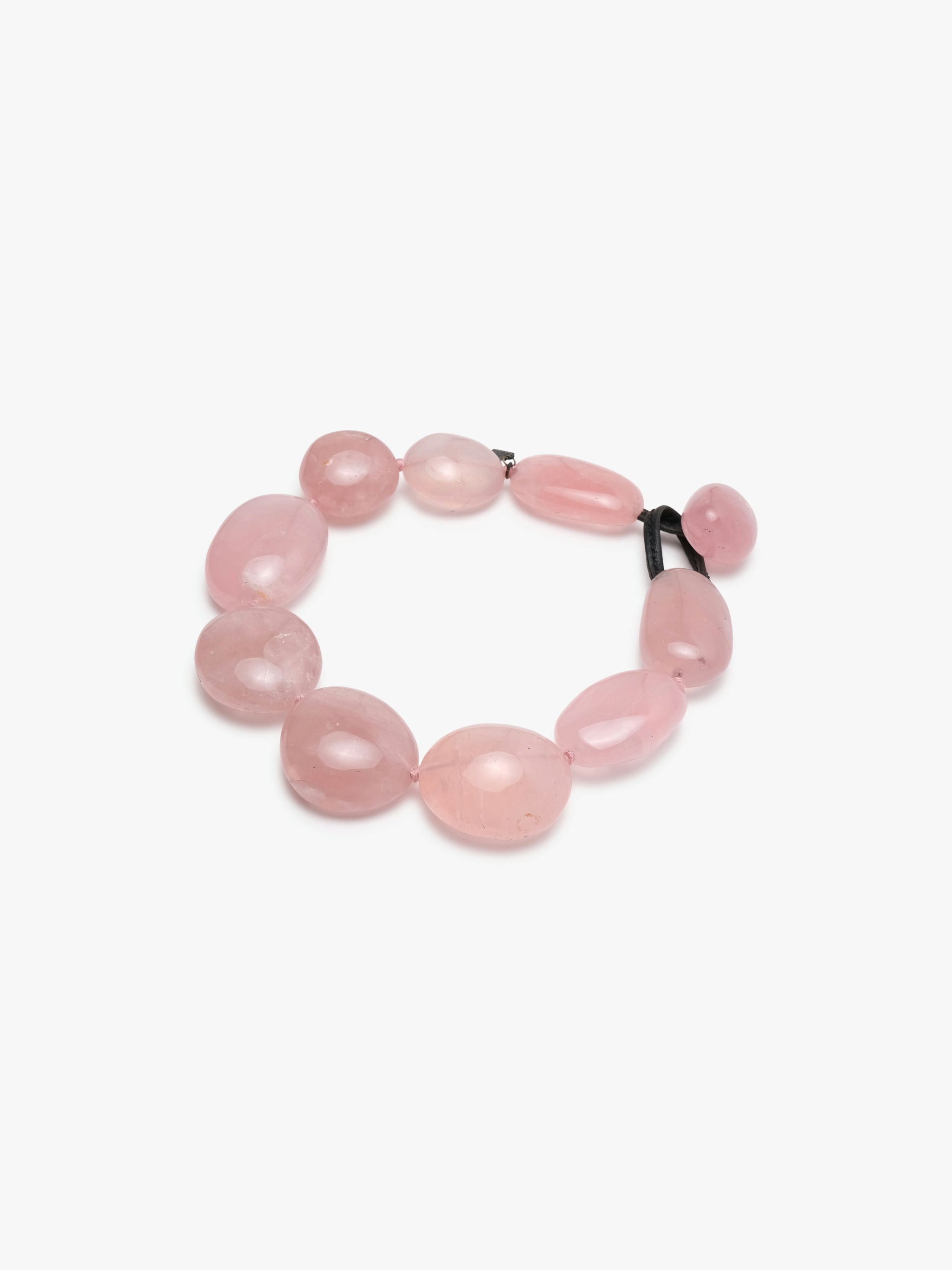 A necklace made of rose quartz with a leather clasp.