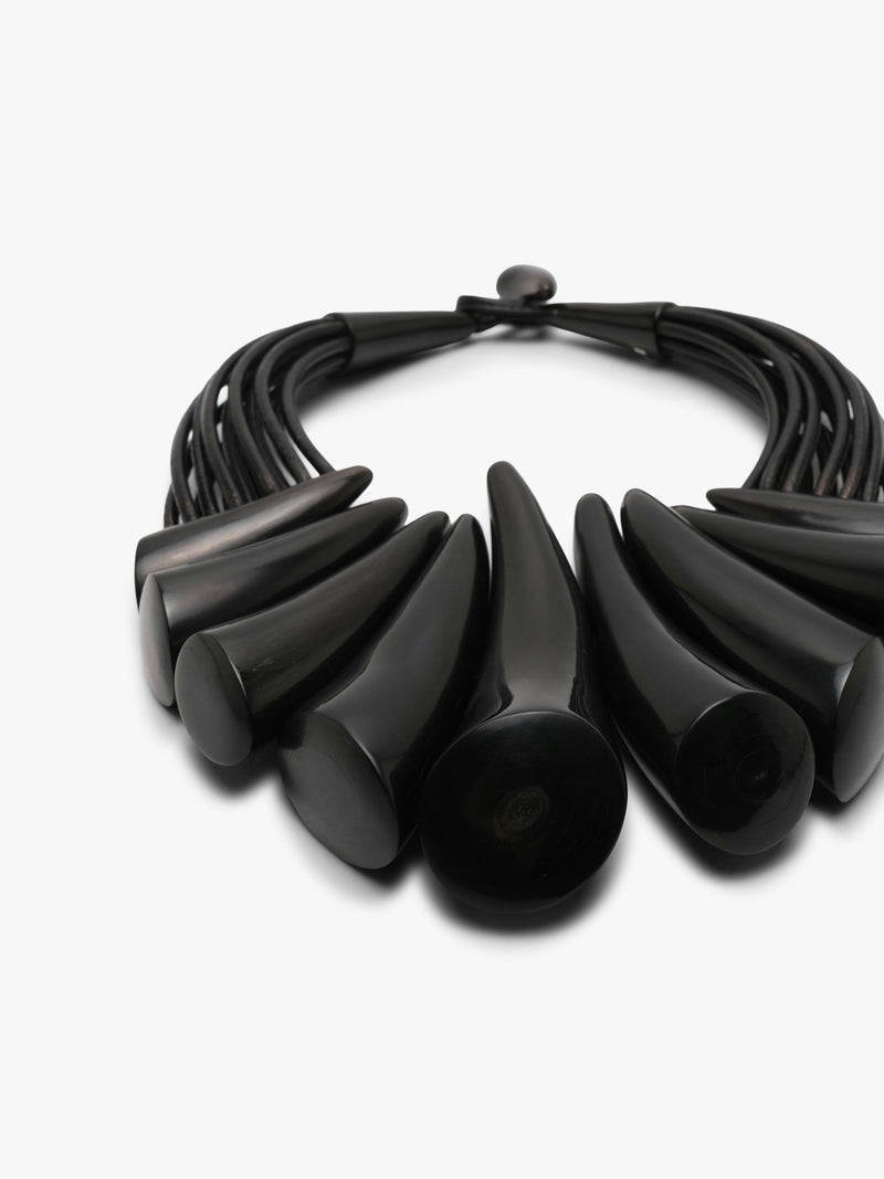 black necklace made from buffalo horn and leather on a white background.