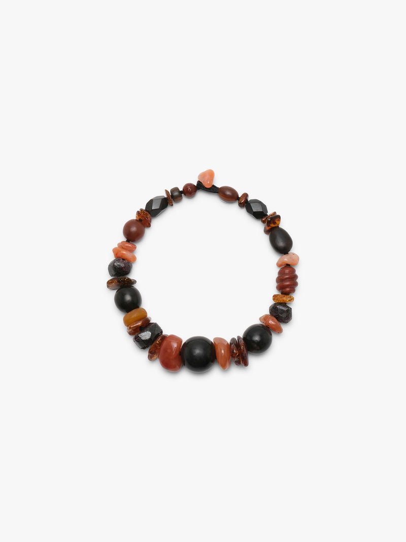 necklace of orange and black stones on white background