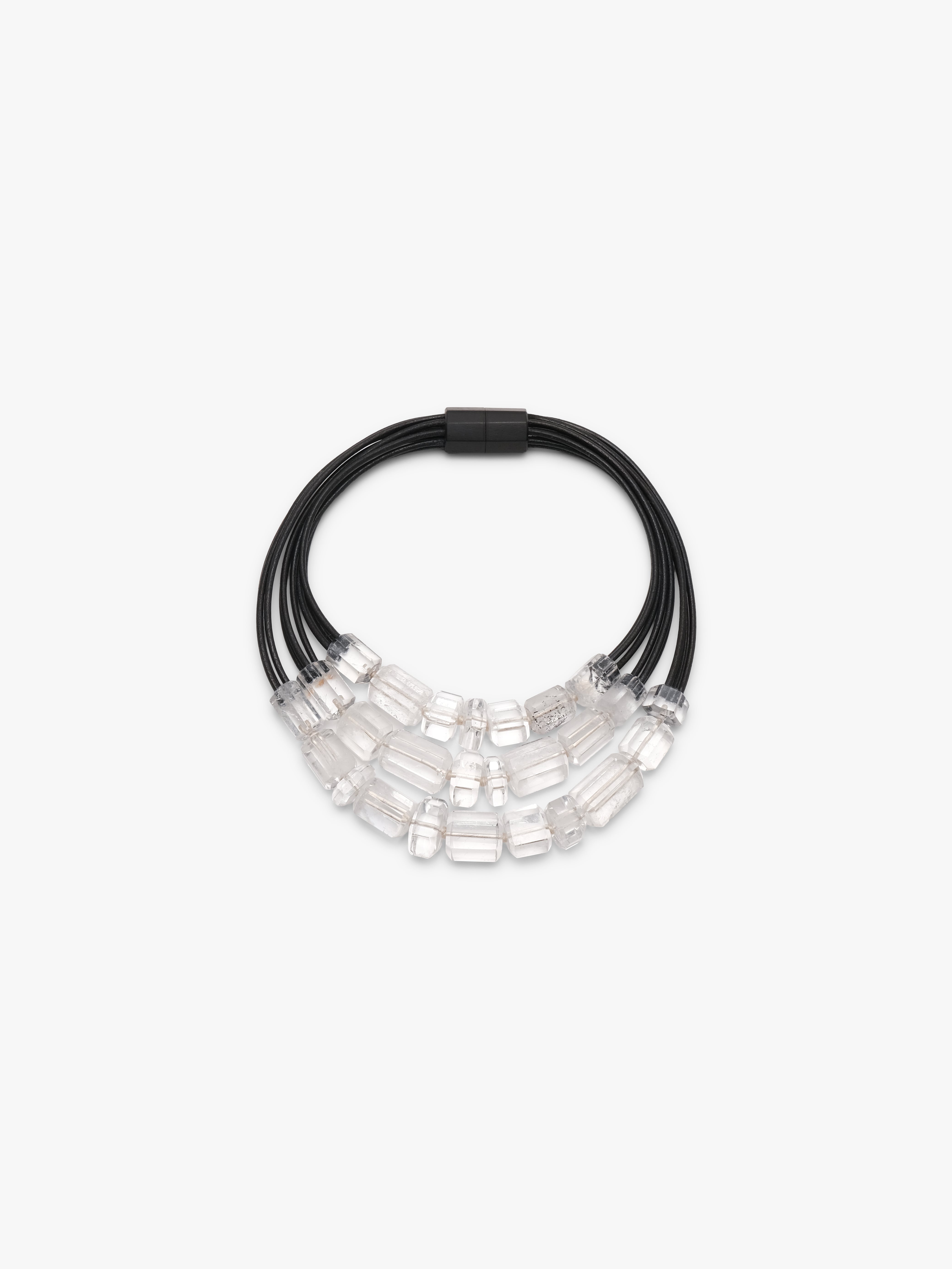 Necklace with black cord and clear mountain crystal beads on a white background