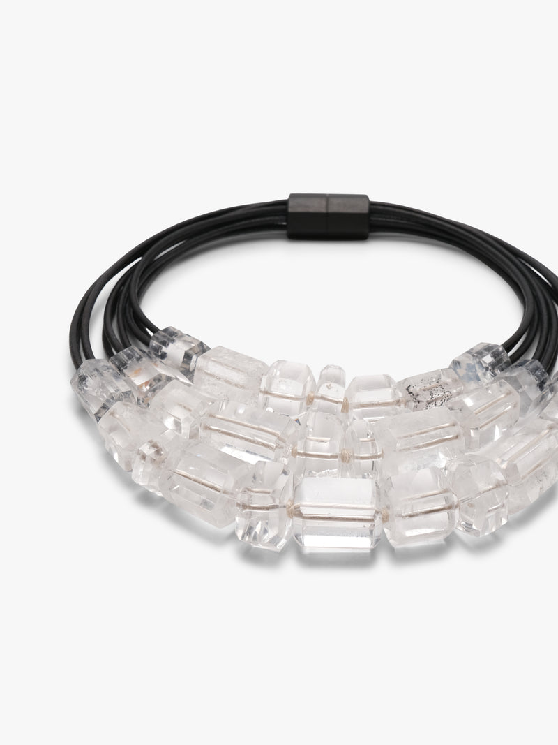 Necklace with black cord and clear mountain crystal beads on a white background