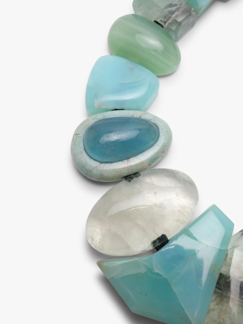 Close up of turquoise beaded necklace on a white background