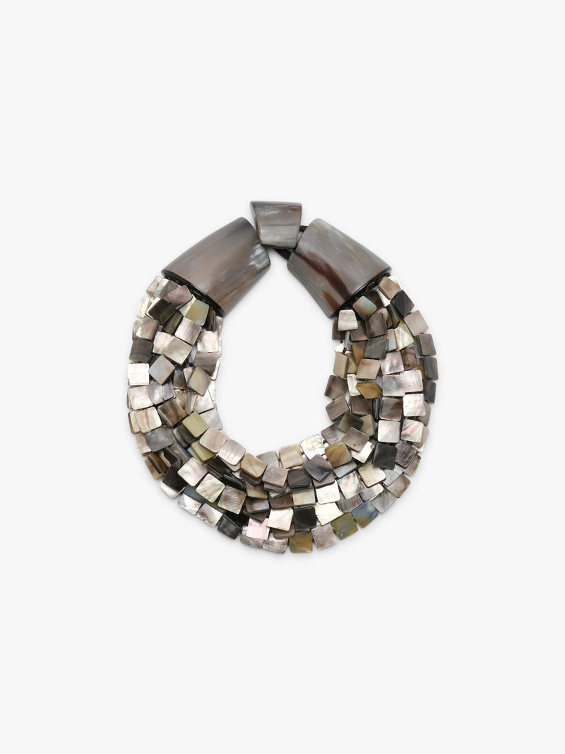 A multi-strand statement necklace featuring polished metallic square beads in silver, bronze, and gold tones, accented by two large dark brown shell-like end caps, shown on a plain light gray background.