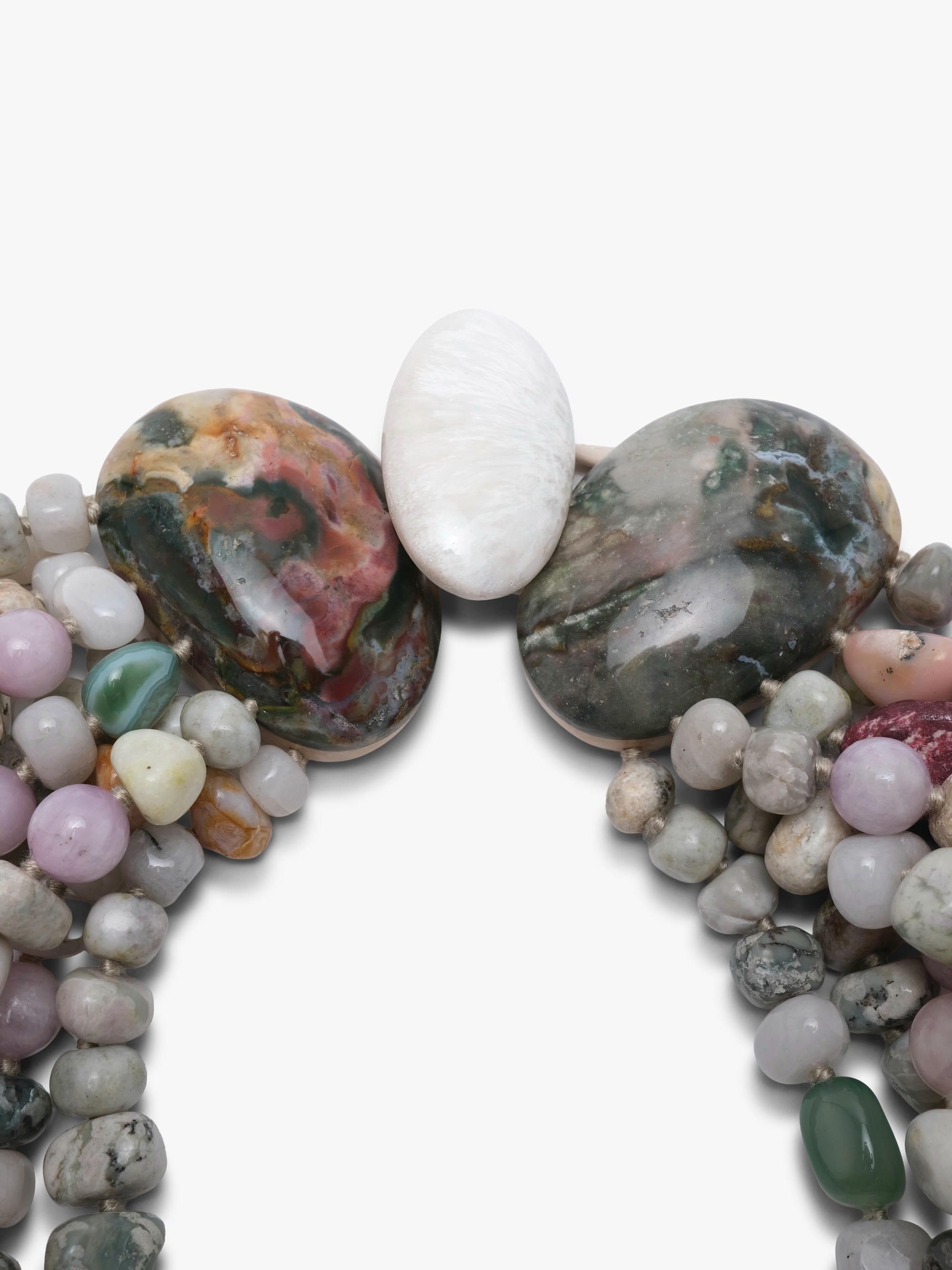 A close-up of a beaded jewelry piece featuring two large polished stones on either side, a central white oval stone, and multiple strands of small multicolored beads on a plain white background.