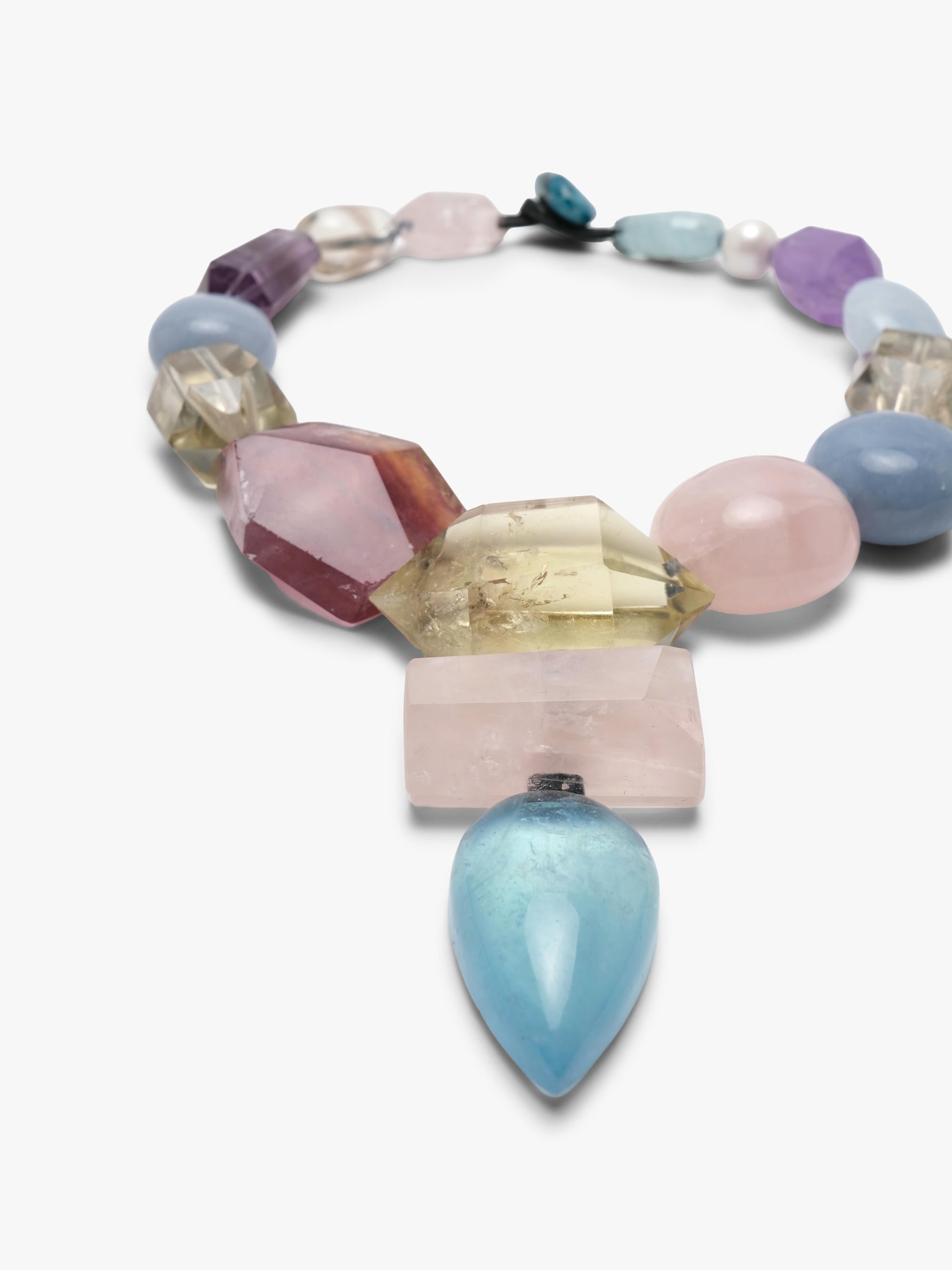 A multicolor gemstone beaded necklace with a large teardrop-shaped blue stone pendant, displayed on a clean white background.