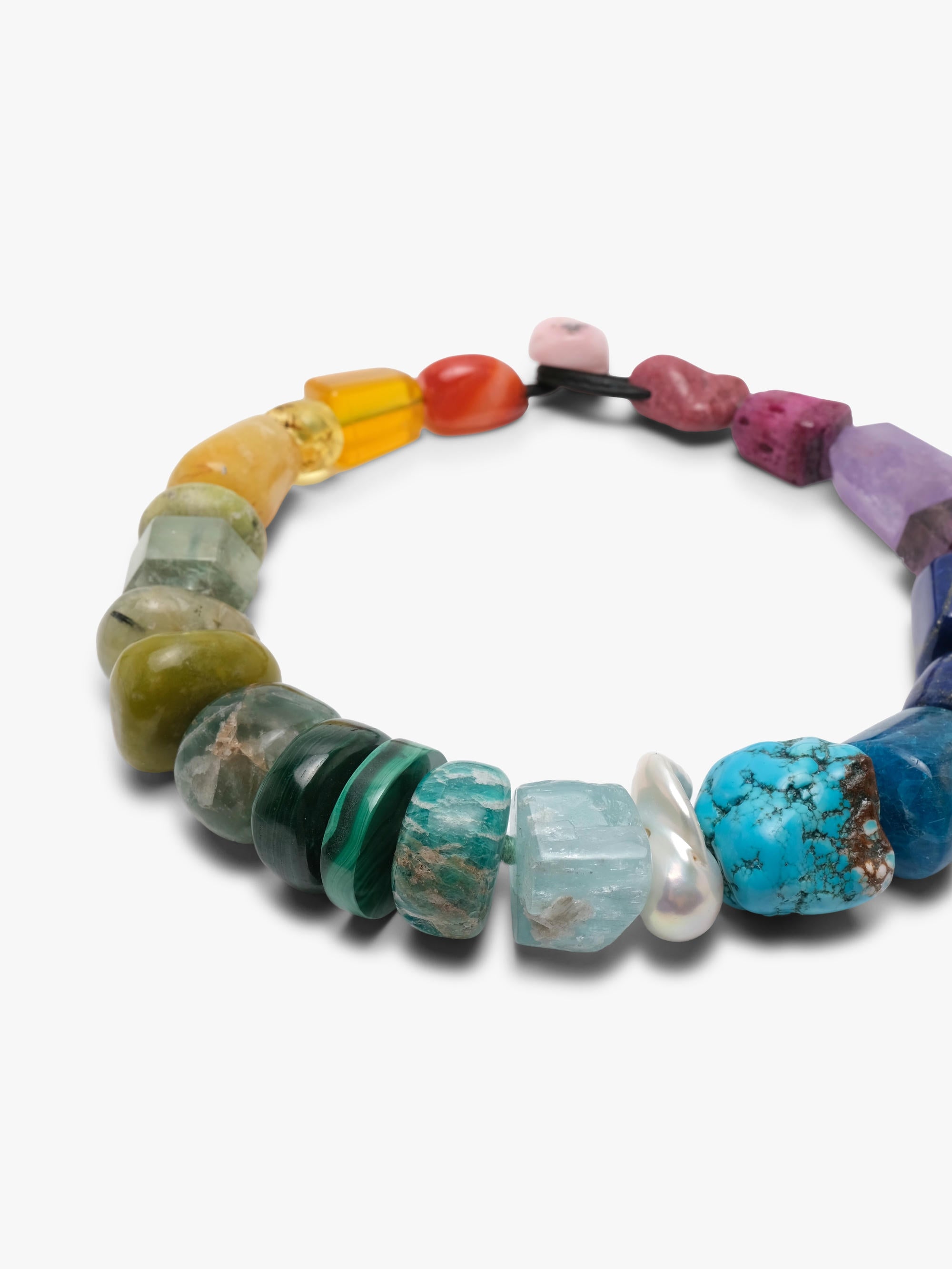 A multicolor gemstone beaded necklace arranged in a circle on a plain white background.