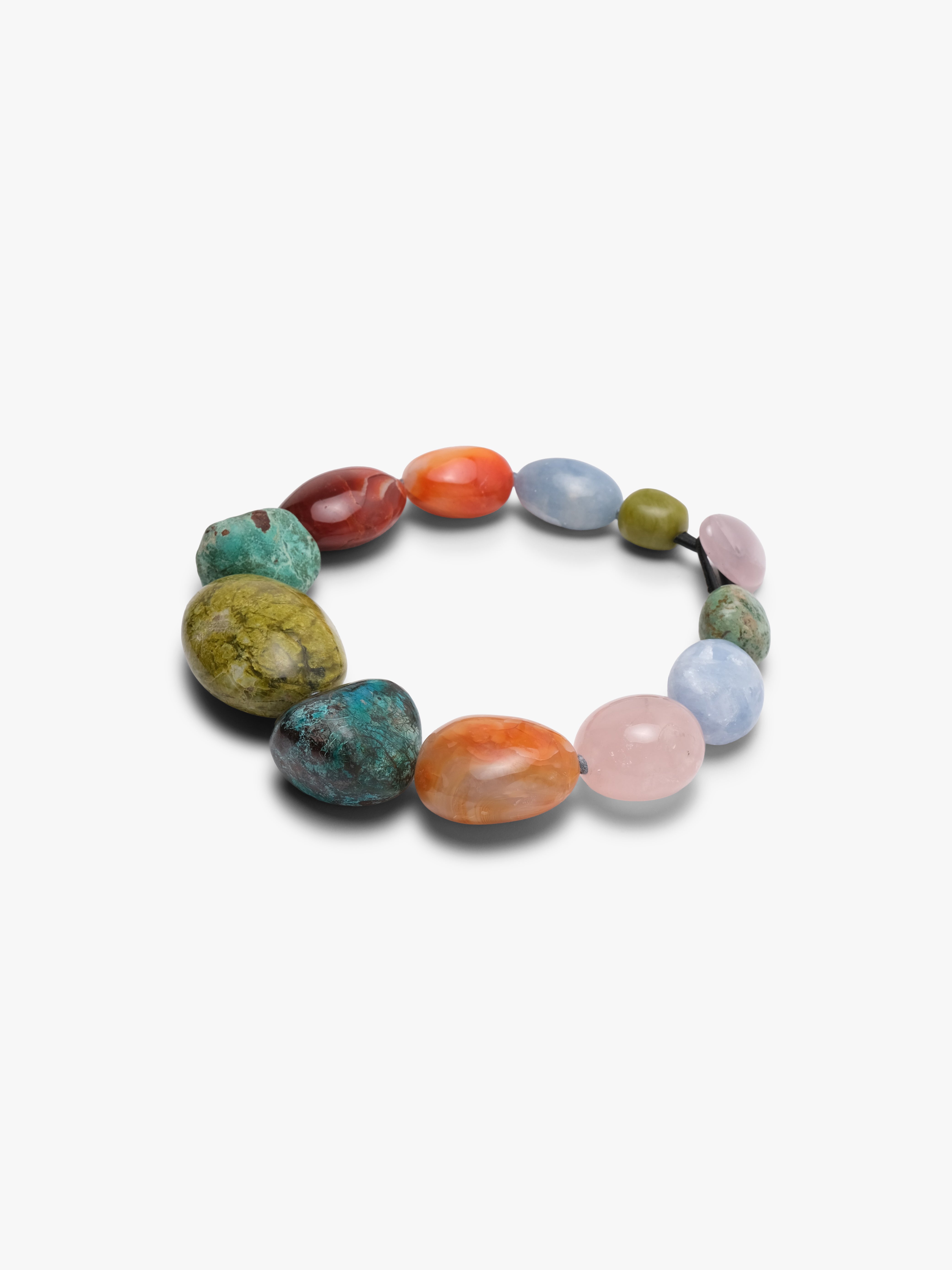 A multicolor stone bead necklace featuring a large central olive-green stone, surrounded by smaller stones in turquoise, coral, red, pink, and light blue, arranged on a light gray background.