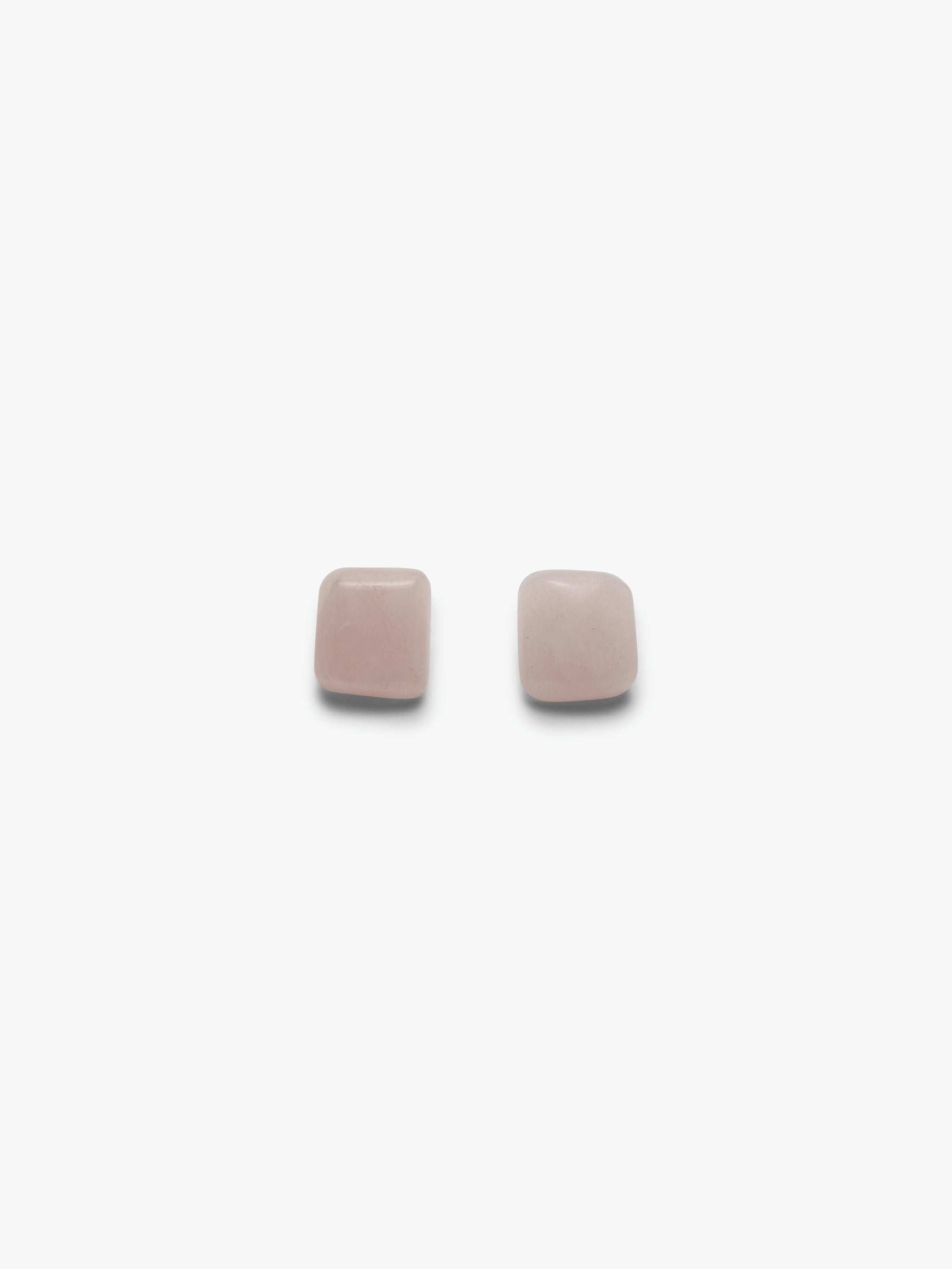 A pair of rose quartz stud earrings against a white background